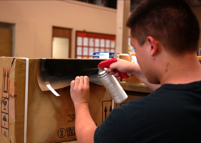 MOODY AIR FORCE BASE, Ga. – Airman 1st Class David Ivester, 23rd Logistics Readiness Squadron traffic management office apprentice, spray paints a stencil onto a packaged box here Sept. 15. Using spray paint and a stencil, Airman Ivester,  makes his work quick and easy. (U.S. Air Force photo by Airman Joshua Green)  