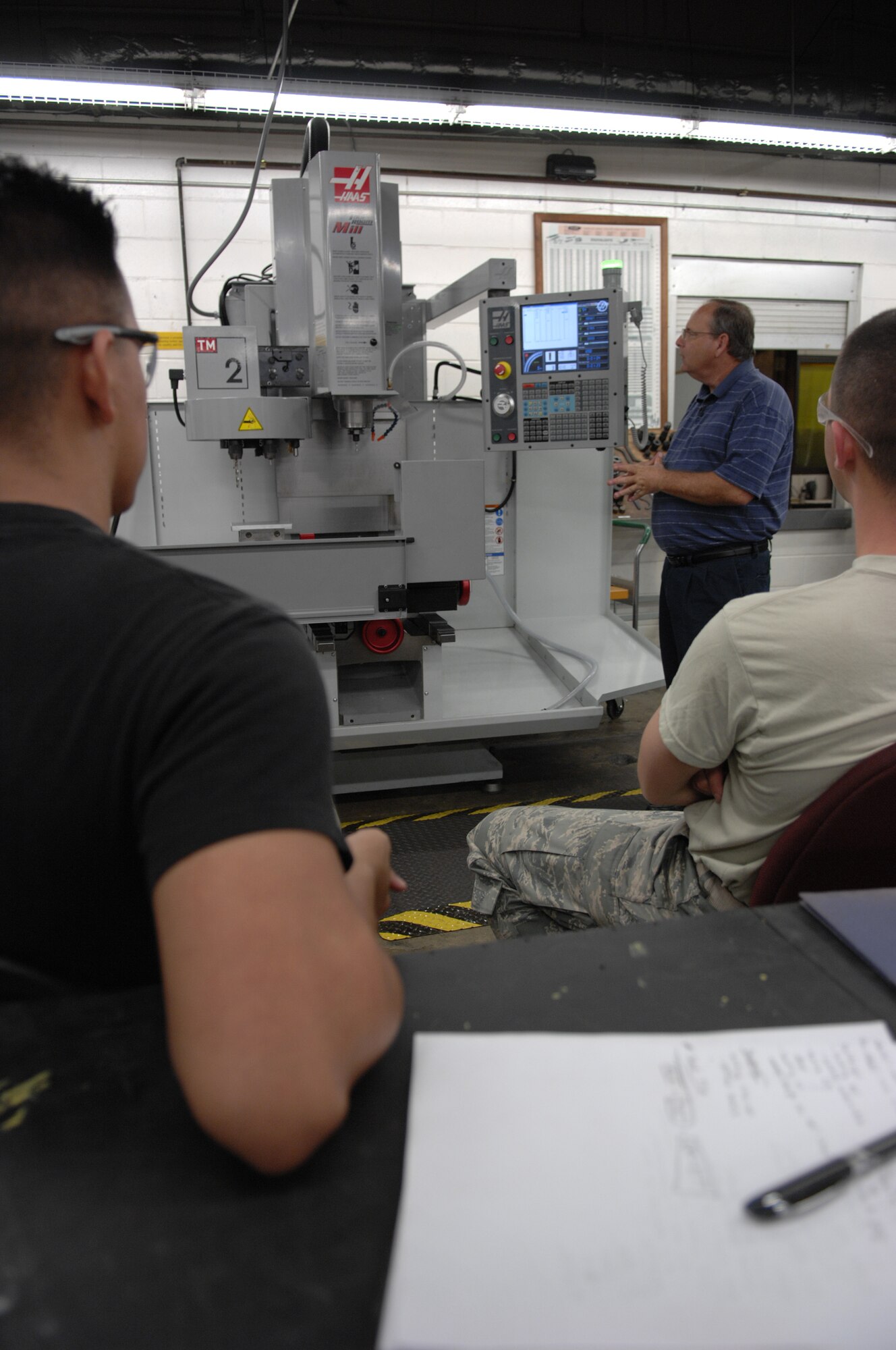 MOODY AIR FORCE BASE, Ga. -- Jeff Foster (right front), Philips Corporation computer numerical control applications and education division, instructs five 23rd Equipment Maintenance Squadron Aircraft Metals Technology airmen on how to use and write programs for a new mill machine here August 26. This new mill will replace outdated existing equipment and improve fabrication time and safety. (U.S. Air Force photo by Senior Airman Javier Cruz)