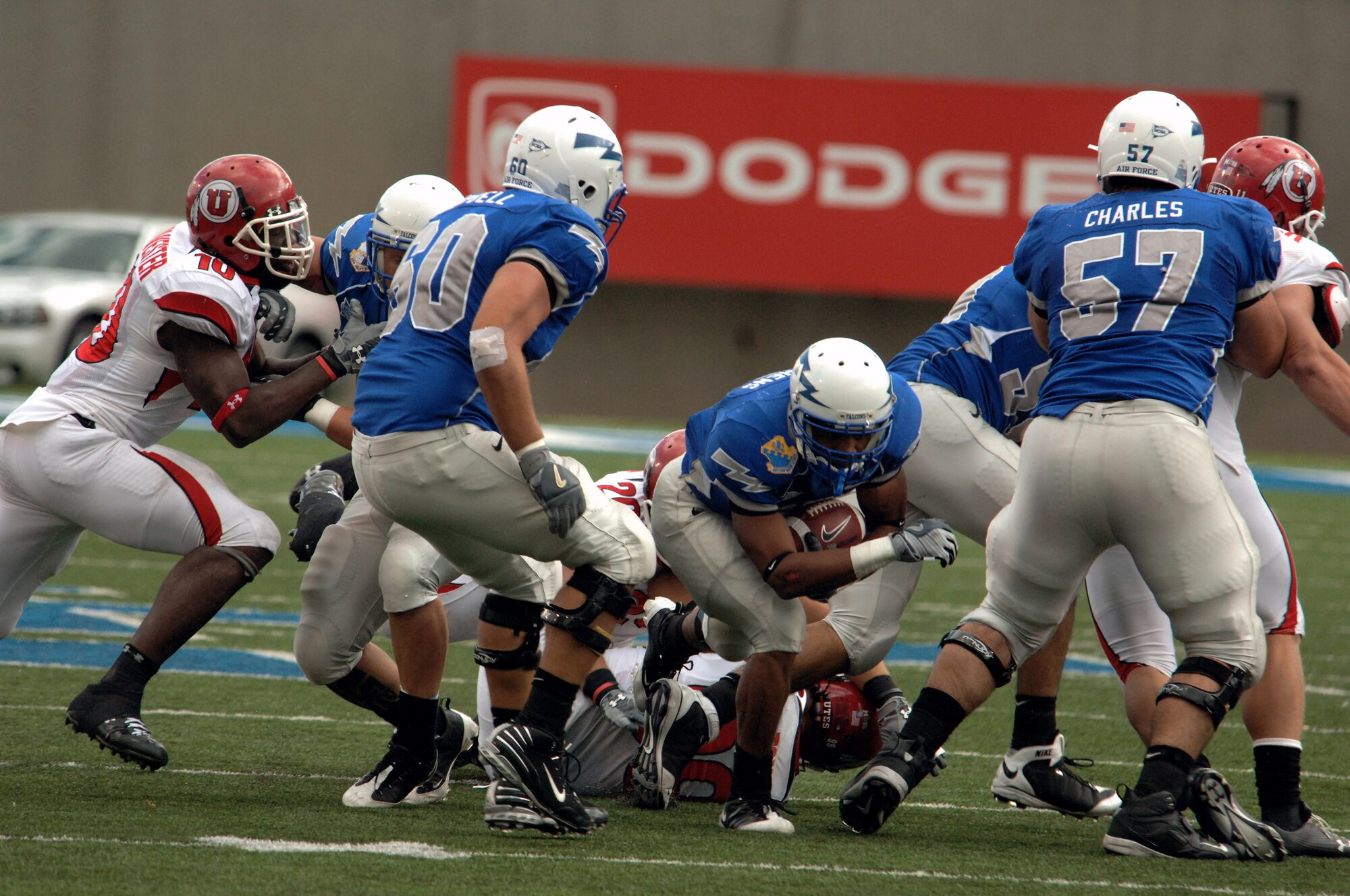 U.S. Air Force Academy tailback Savier Stephens dives through a hole opened by the Falcon offensive line, led by tackle Chris Campbell and guard Nick Charles Sept. 20 at the Academy in Colorado. Stephens rushed 13 times for 33 yards in the Falcons 30-23 loss to No. 20 Utah. (U.S. Air Force photo/John Van Winkle) 
