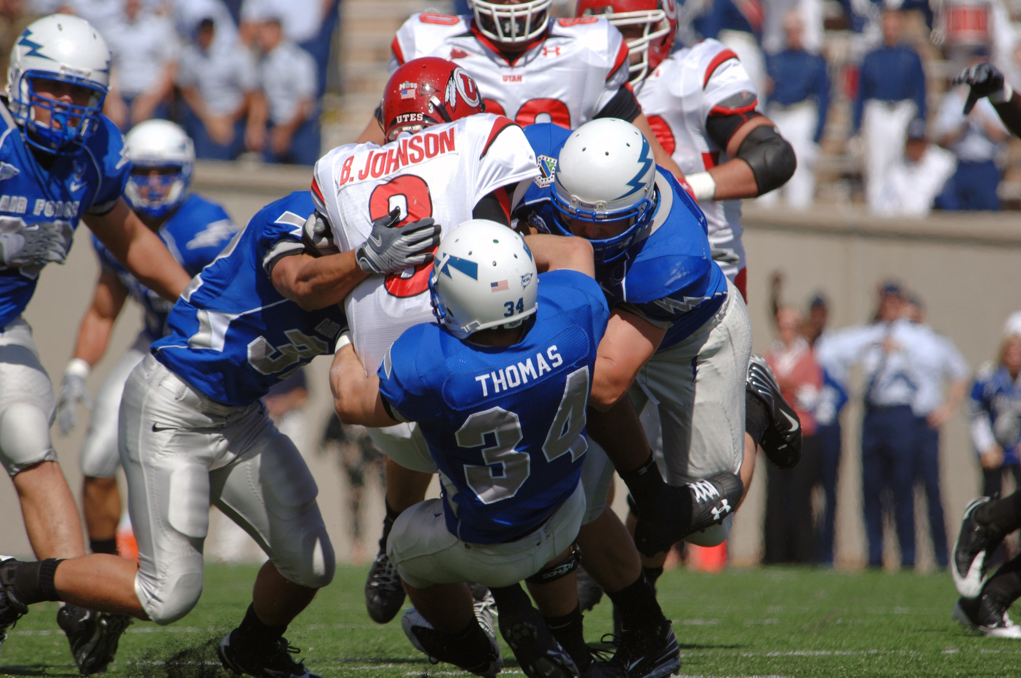 Utah quarterback Brian Johnson gets mobbed for a loss by U.S. Air Force Academy linebacker Hunter Altman, safety Chris Thomas and defensive end Ryan Kemp Sept. 20 at the Academy in Colorado. (U.S. Air Force photo/John Van Winkle) 
