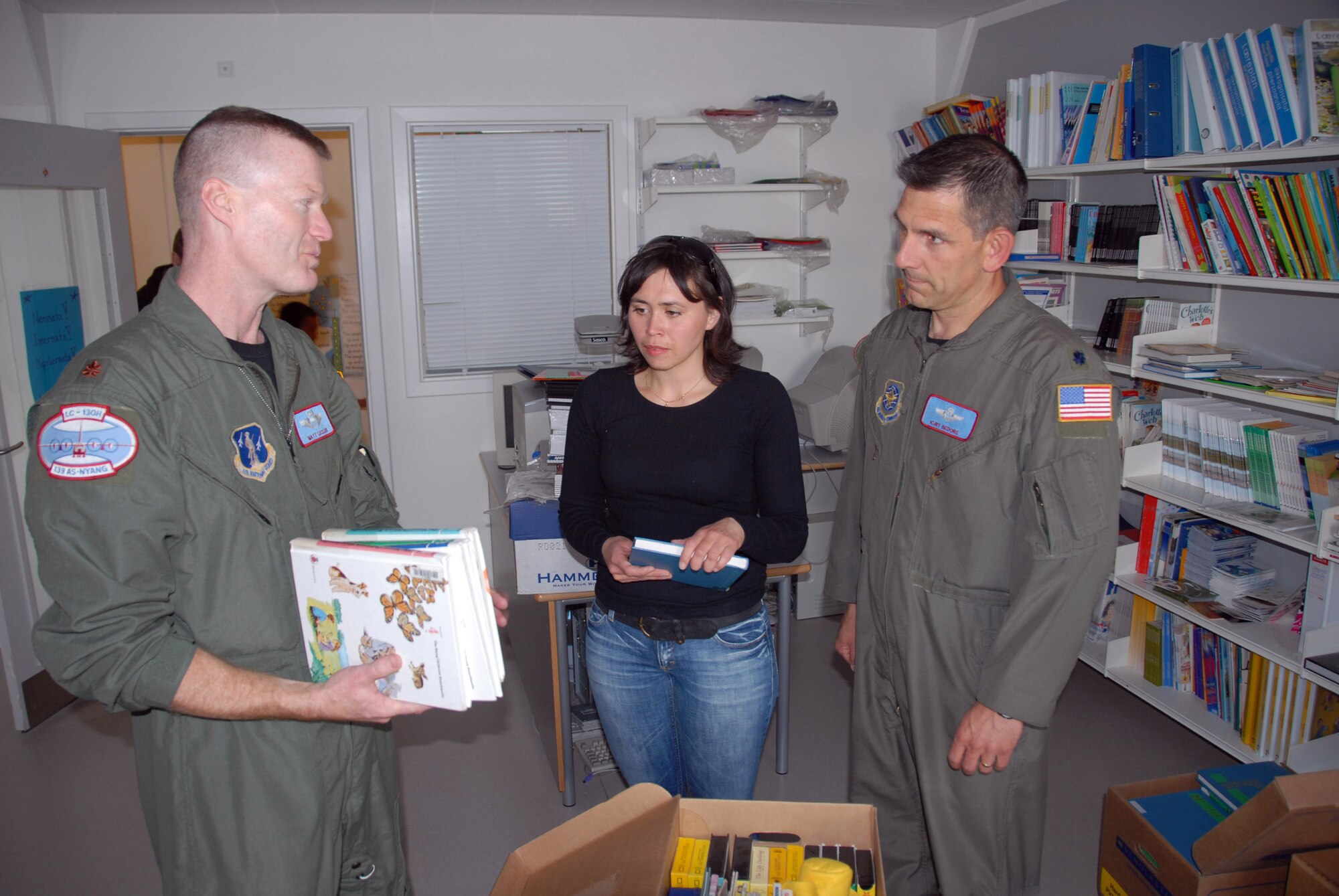 Maj. Matt LeClair and Lt. Col. Kurt Bedore drop off books to Elsemarie Asmussen, an English teacher at Qinngulata Atuarfia Elementary School in Greenland. Books have been donated by schools in the Scotia area. (U.S. Air Force photo by Master Sgt. Christine Wood)