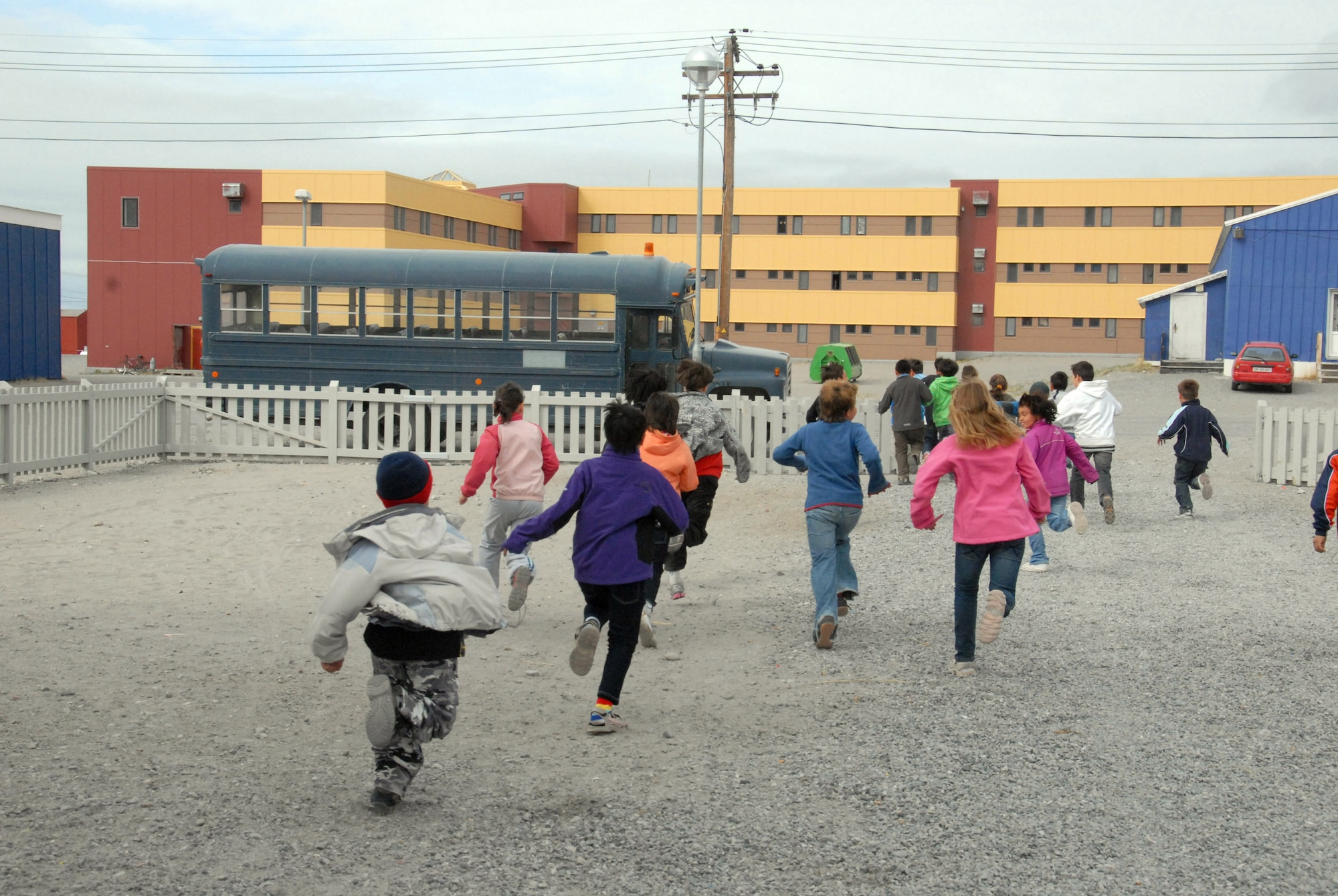 Students in Greenland run to the bus that will take them to the flightline to tour a 109th Airlift Wing LC-130 Hercules. The tour was part of a community day 109th AW members organized for the elementary school. (U.S. Air Force photo by Master Sgt. Christine Wood)
