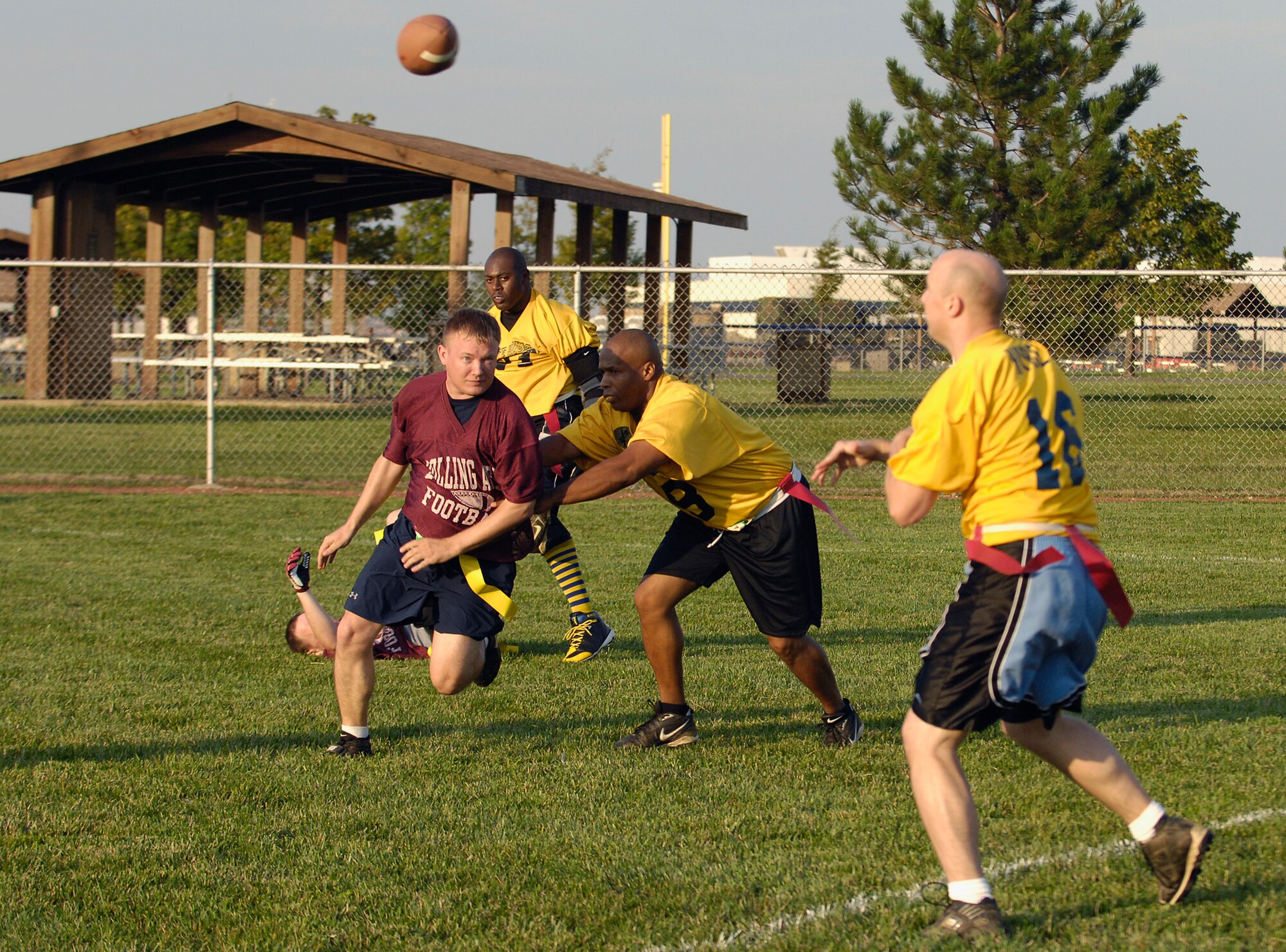 A defensive linemen from the 744th Communications Group rushes the quaterback from White House Communications Agency Sept. 18 in a game during the first week of Bolling's flag football competition. The CG went on to beat WHCA, 24 - 19. (U.S. Air Force photo by Senior Airman Dan DeCook)