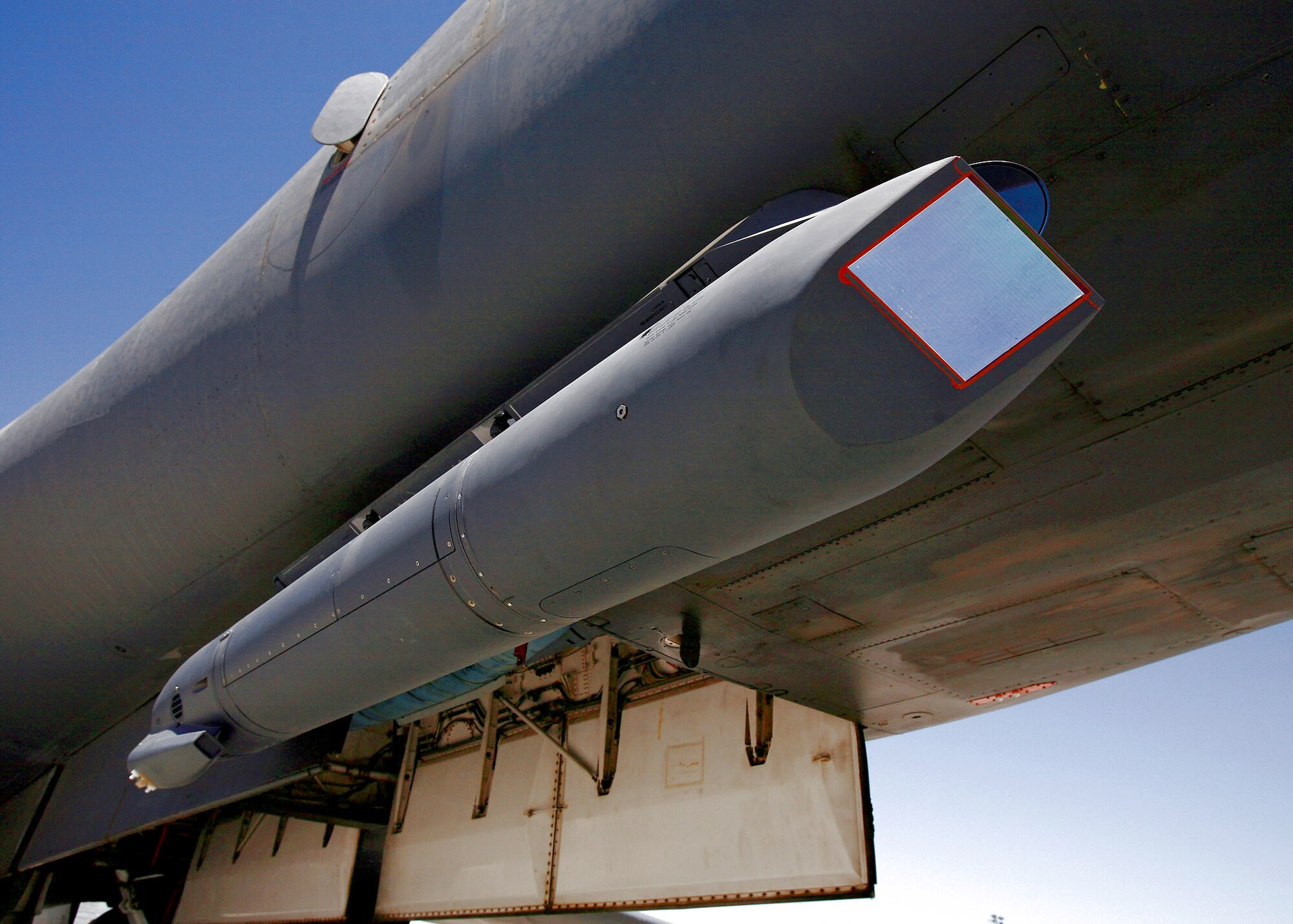 A sniper pod rests on the lower right of a B-1B Lancer fuselage. The sniper pod allows the aircrew to positively identify a target and quickly assess battle damage after an attack. (U.S. Air Force photo/Jet Fabara) 
