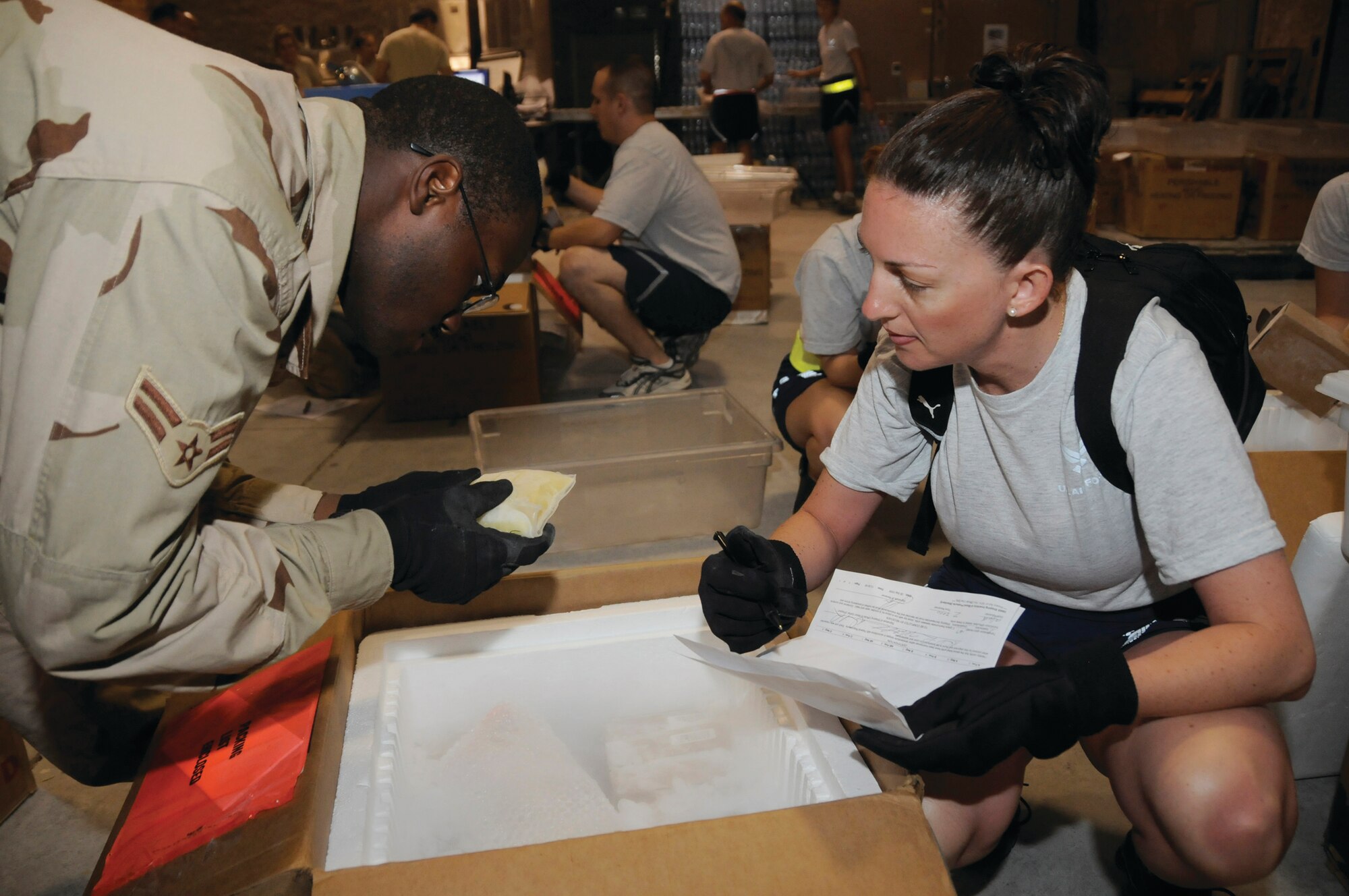 SOUTHWEST ASIA -- Airman 1st Class Deitric Thompson (left), 379th Expeditionary Security Forces Squadron member, verifies that the manifest on the plasma matches the box manifest checked by Master Sgt. Blenda Mease, 379th Air Expeditionary Wing controller, at the Blood Transshipment Center here Sept. 13. The blood transshipment center delivers blood to 42 U.S. Armed Forces medical treatment facilities plus five Coalition hospitals. Airman Thompson, a native of Memphis, Tenn., is deployed from Nellis Air Force Base, Nev., and Sergeant Mease, a native of Los Angeles, Calif., is deployed from Vandenberg Air Force Base, Calif. (U.S. Air Force Photo by Staff Sgt. Darnell T. Cannady)