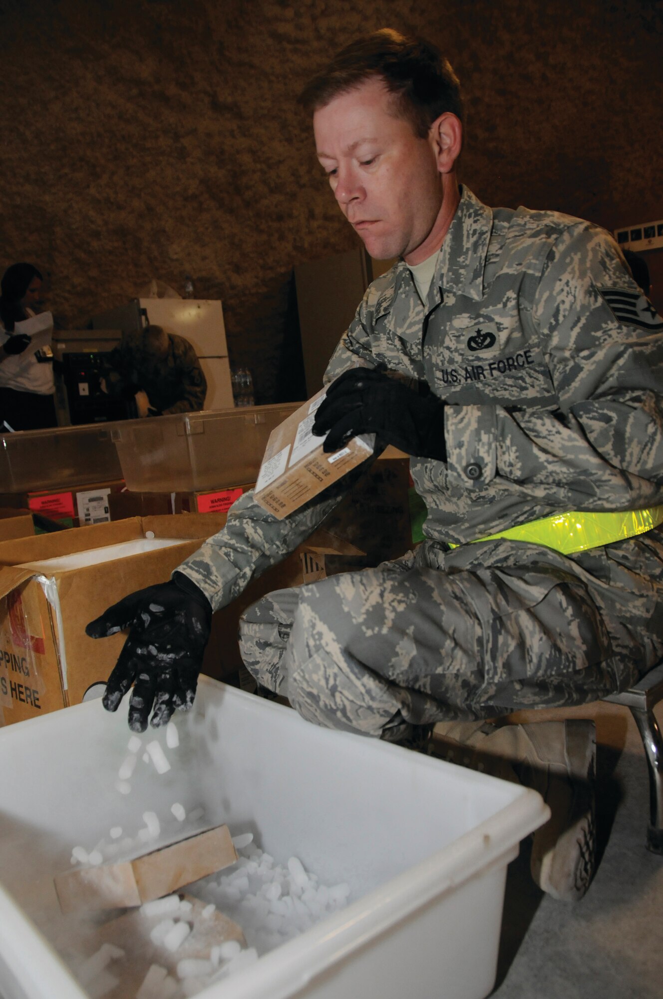 SOUTHWEST ASIA -- Staff Sgt. David Tripp, 379th Expeditionary Civil Engineer Squadron utilities technician, puts dry ice into a container containing plasma while verifying the manifest matches the information on the plasma at the blood transshipment center here Sept. 13. On average, 30 servicemembers sacrifice their sleep to volunteer late at night at the BTC. Sergeant Tripp, a native of New Castle, Va., is deployed from Pope Air Force Base, N.C. (U.S. Air Force Photo by Staff Sgt. Darnell T. Cannady)