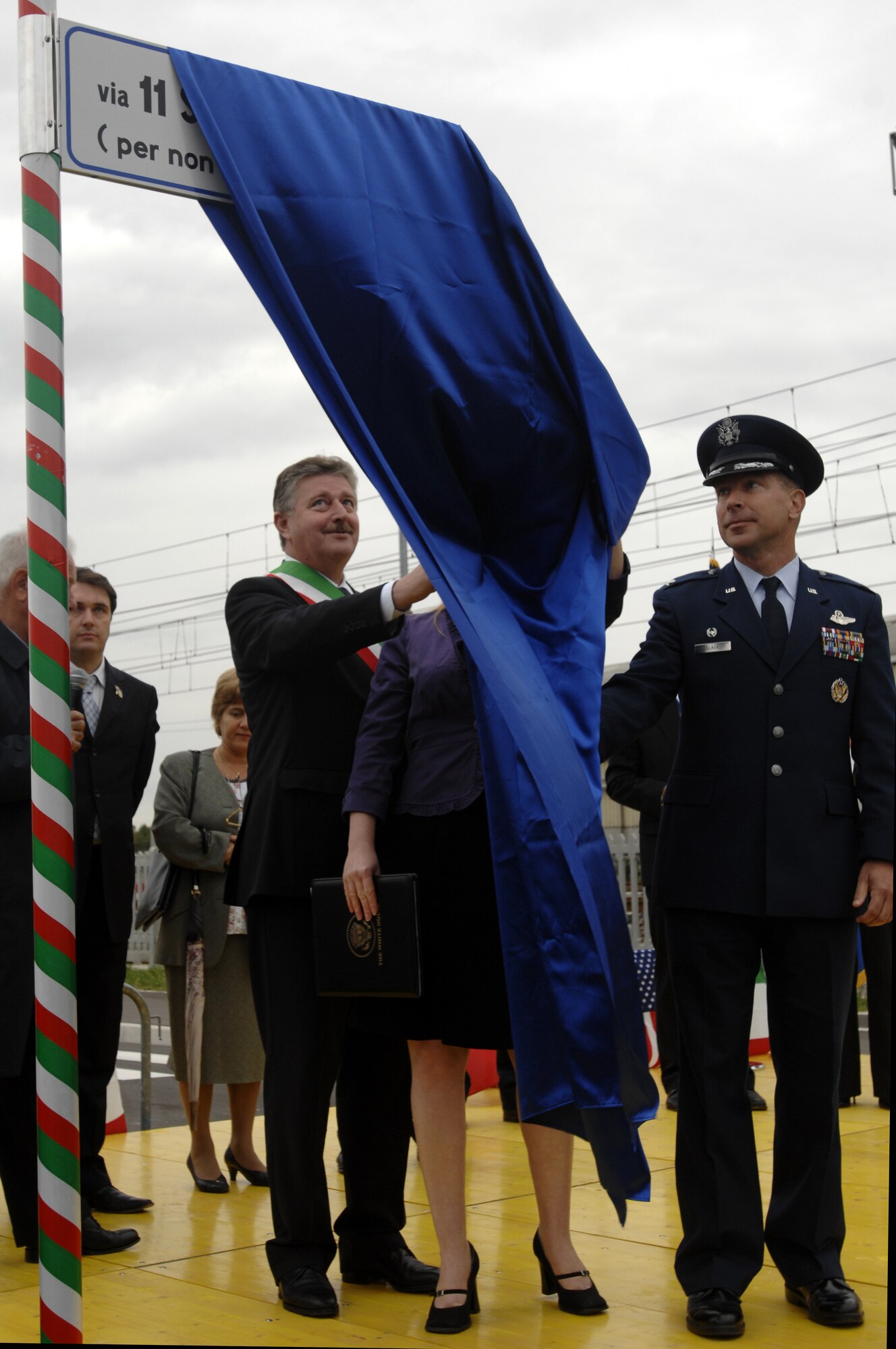 Claudio Tessari, mayor of Spinea, Mrs. Megan Jones, a consul from the U.S. consulate agency in Venice, and Colonel David Slade, 31st Mission Support Group commander, unveil a new street sign in Spinea, Italy on Sept. 21, 2008. The street is named in honor of those who died during the Sept. 11, 2001 terrorist attacks. The sign states " Via 11 settembre 2001 (per non dimenticare mai)" which means "So we will never forget."  (U.S. Air Force photo/Airman 1st Class Ashley Wood) 