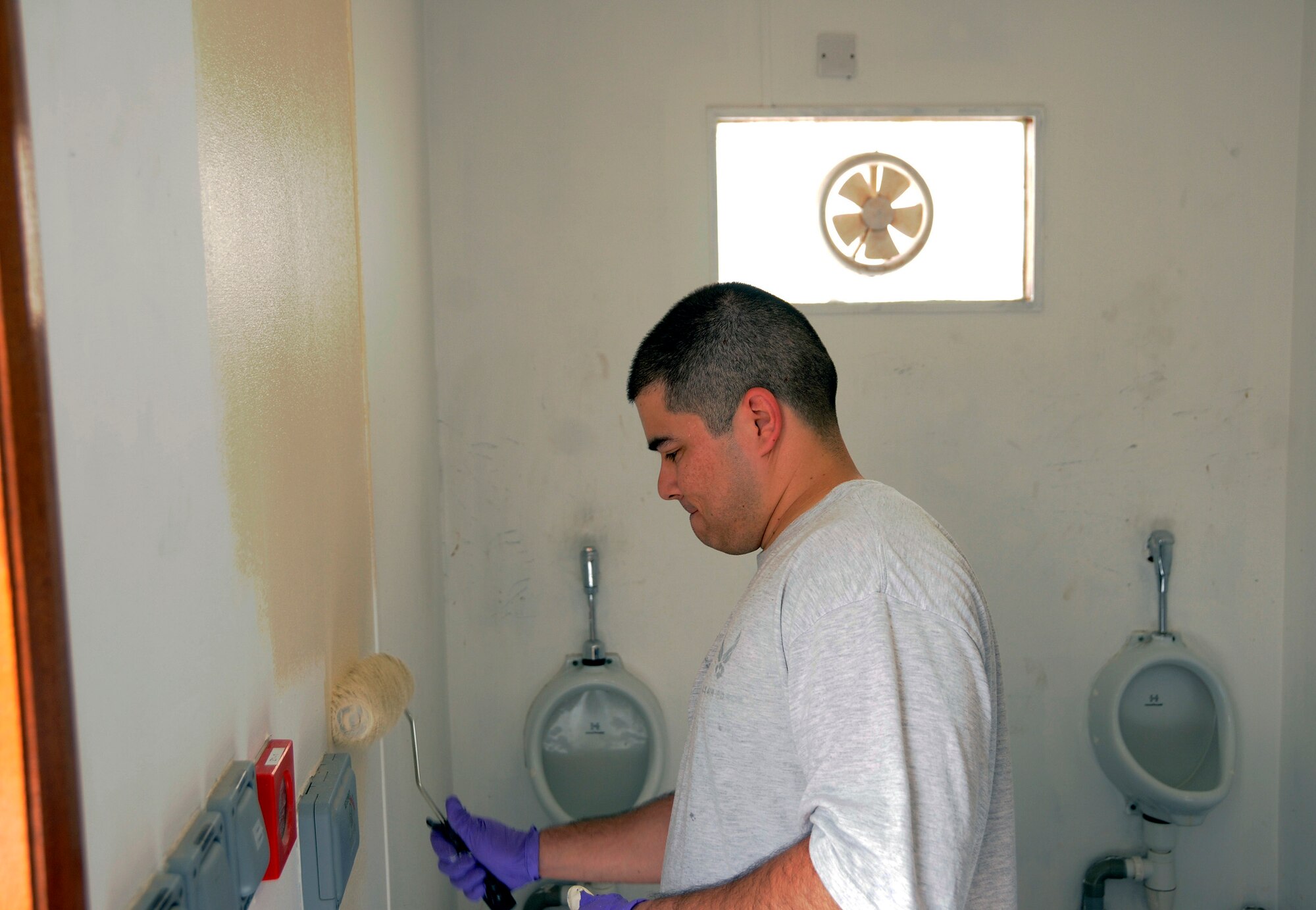 Staff Sgt. Puro Jimenez, 379th Expeditionary Force Support Squadron, uses a roller to apply a layer of fresh paint during an effort by EFSS to take ownership and bring up to Air Force standards the outdoor latrine facility located nearest their office Sept. 21, 2008.  The latrines were cleaned, scraped, sanded and painted as part of the clean up operation at an undisclosed air base in Southwest Asia.  Sergeant Jimenez, a native of Brooklyn, N.Y., is deployed from MacDill Air Force Base, Fla., in support of Operations Iraqi and Enduring Freedom and Joint Task Force-Horn of Africa.  (U.S. Air Force photo by Tech. Sgt. Michael Boquette/Released)