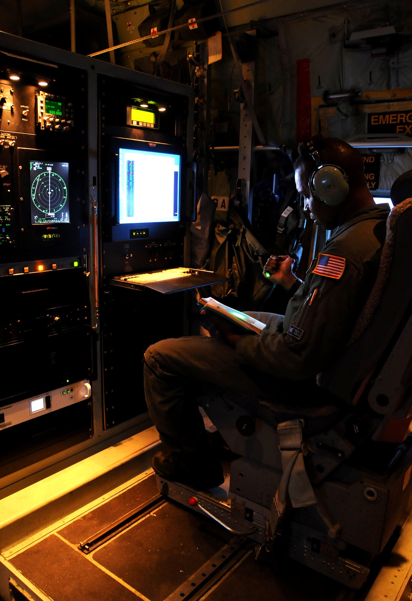 ANDERSEN AIR FORCE BASE, Guam - Technical Sgt. Vincent Burden, 53rd Weather Reconnaissance Squadron weather loadmaster, reviews a technical order while seated in the aerial weather reconnaissance officer?s position aboard a Air Force Reserve WC-130J Sept. 20. The 53rd WRS, deployed here from Keesler AFB, Miss., to conduct meteorological research on tropical cyclones in the Western Pacific.  The study runs through the end of September. (U.S. Air Force photo by Airman 1st Class Courtney Witt)
