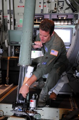 ANDERSEN AIR FORCE BASE, Guam - Master Sgt. Jeff Stack, 53rd Weather Reconnaissance Squadron weather  loadmaster, demonstrates how dropsondes are deployed from the WC-130. The Air Force Reserve?s 53rd WRS uses dropsondes to record wind speed, wind direction, atmospheric pressure in typhoons. The 53rd WRS, deployed here from Keesler AFB, Miss., to conduct meteorological research on tropical cyclones in the Western Pacific . The study runs through the end of September. (U.S. Air Force photo by Airman 1st Class Courtney Witt)

