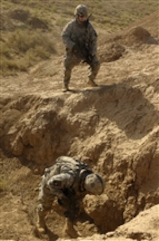 U.S. Army soldiers inspect holes as they search for weapons caches during Operation Dimaggio in Yathreeb, Iraq, on June 28, 2008.  The soldiers are assigned to the 1st Platoon, Bravo Battery, 2nd Battalion, 320th Field Artillery Regiment.  