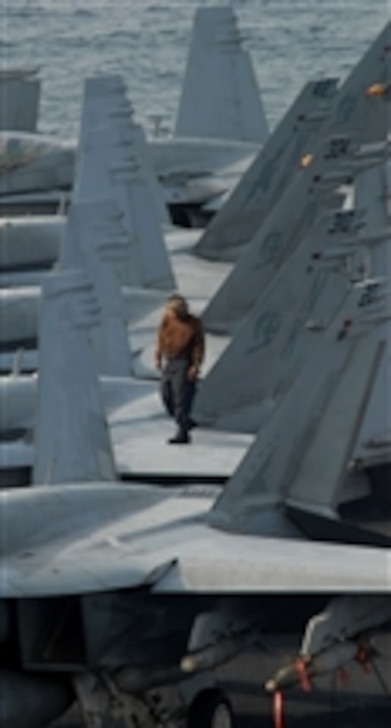 A plane captain walks down the wing of an F/A-18C Hornet aircraft assigned to Strike Fighter Squadron 113 on the flight deck of the aircraft carrier USS Ronald Reagan (CVN 76) while underway in the Gulf of Oman on Sept. 18, 2008.  Plane captains perform safety inspections and maintain general cleanliness of aircraft.  The Ronald Reagan Carrier Strike Group is deployed to the U.S. 5th Fleet area of responsibility.  