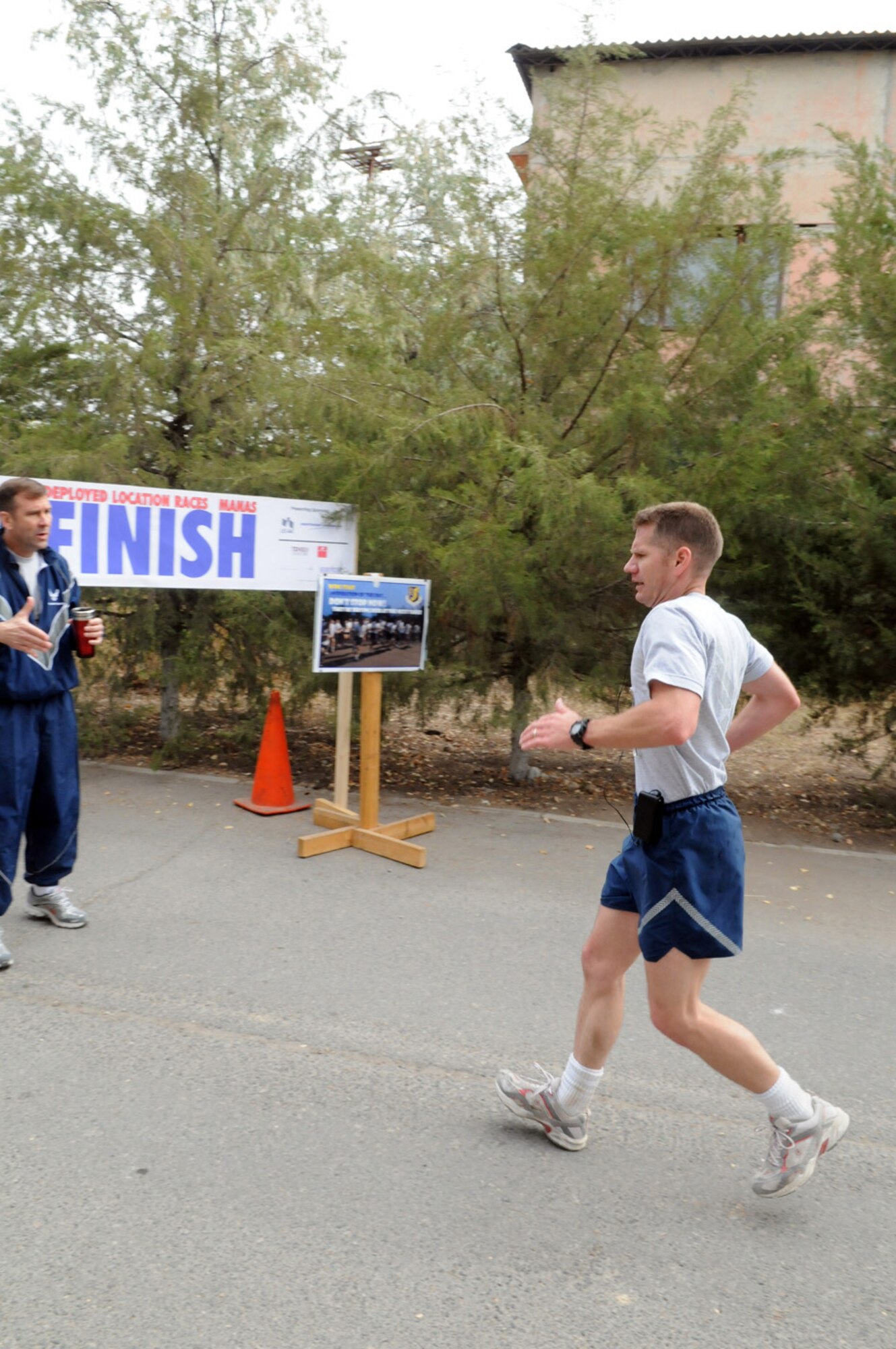 Maj. Damien Pickart grimaces in pain from muscle cramps that came on in the last two miles of the 26.2 mile Manas Air Base version of the Air Force Marathon. More than 40 deployed servicemembers here particapated in the event, Sept. 20. (Air Force photo / Senior Airmen Ruth Holcomb)