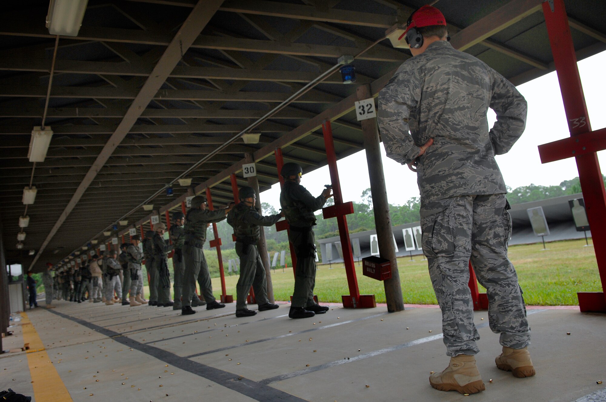 HURLBURT FIELD, Fla. -- Staff Sgt. Kenneth Kline, a 1st Special Operations Security Forces Squadron combat armsman, supervises students shooting a 9 mm handguns during a qualifying course here, Sept.  18. While the students are shooting the combat arms man ensures safety and makes corrections to form.(U.S. Air Force photo/ Senior Airman Julianne Showalter)