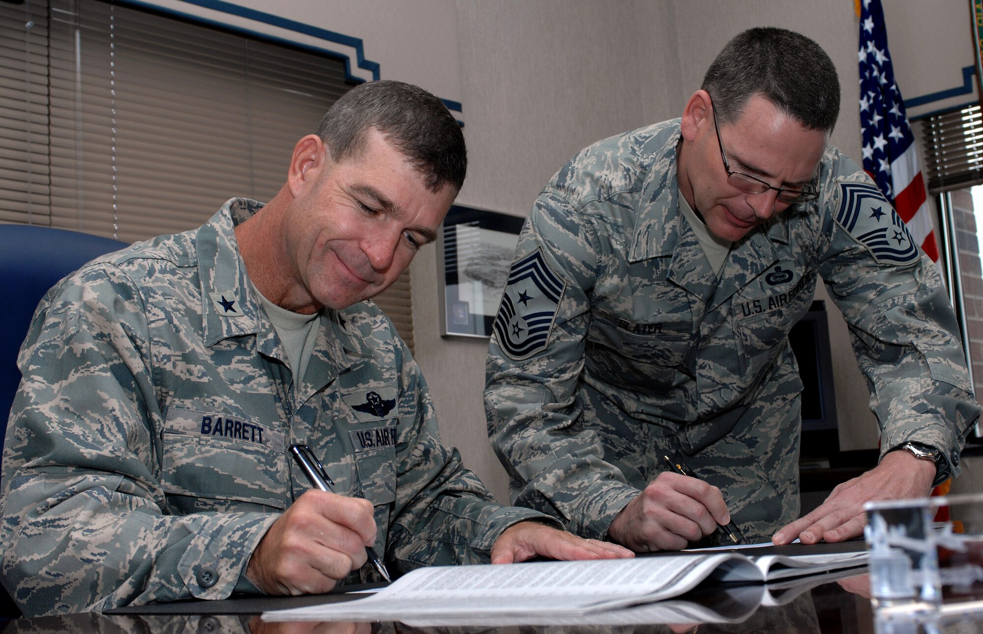 LANGLEY AIR FORCE BASE, Va. -- Brig. Gen. Mark Barrett, 1st Fighter Wing commander and Chief Master Sgt. Kevin Slater, 1st FW command chief, sign checks to donate money to Langley’s 2008 Combined Federal Campaign Sept. 23.  The program provides federal employees with an opportunity to support local national and international charities. The CFC runs from Oct. 1 to Nov. 7. (U.S. Air Force photo/Airman 1st Class Zachary Wolf)