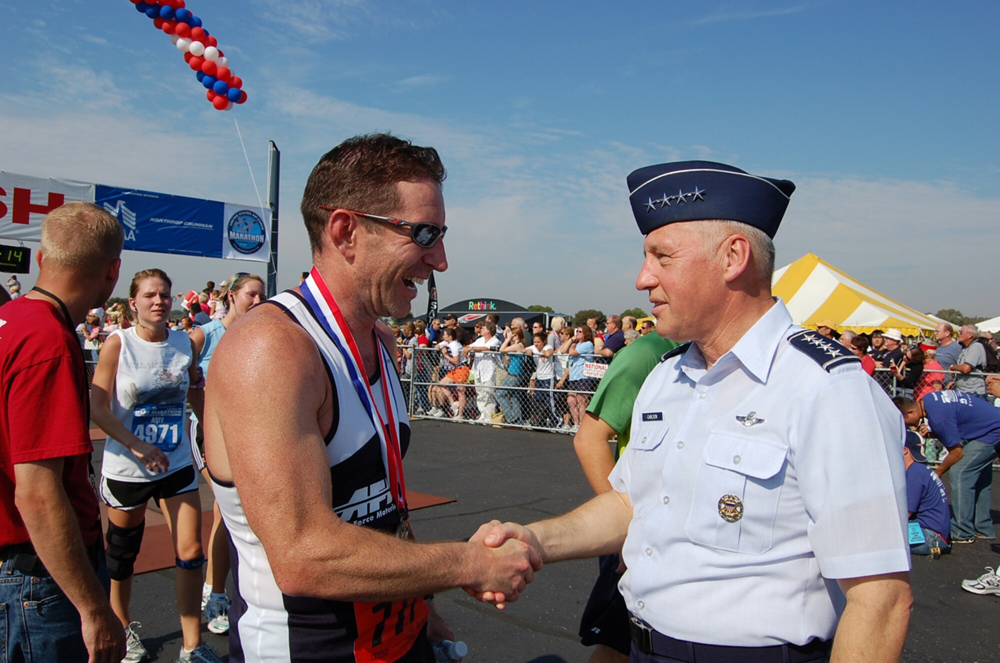 Wright Patterson AFB, Ohio -- Maj. Jeffrey Hammond, 651st Electronic Systems Squadron, is congratulated by Gen. Bruce Carlson, commander of Air Force Materiel Command, after completing the Air Force Marathon held at Wright Patterson Air Force Base, Ohio, Sept. 20. The major, who is assigned to Hanscom, was a member of the AFMC marathon team and finished the event in 3:22:58. He placed 18th in his age category and was the 28th servicemember to finish. (U.S. Air Force courtesy photo)
