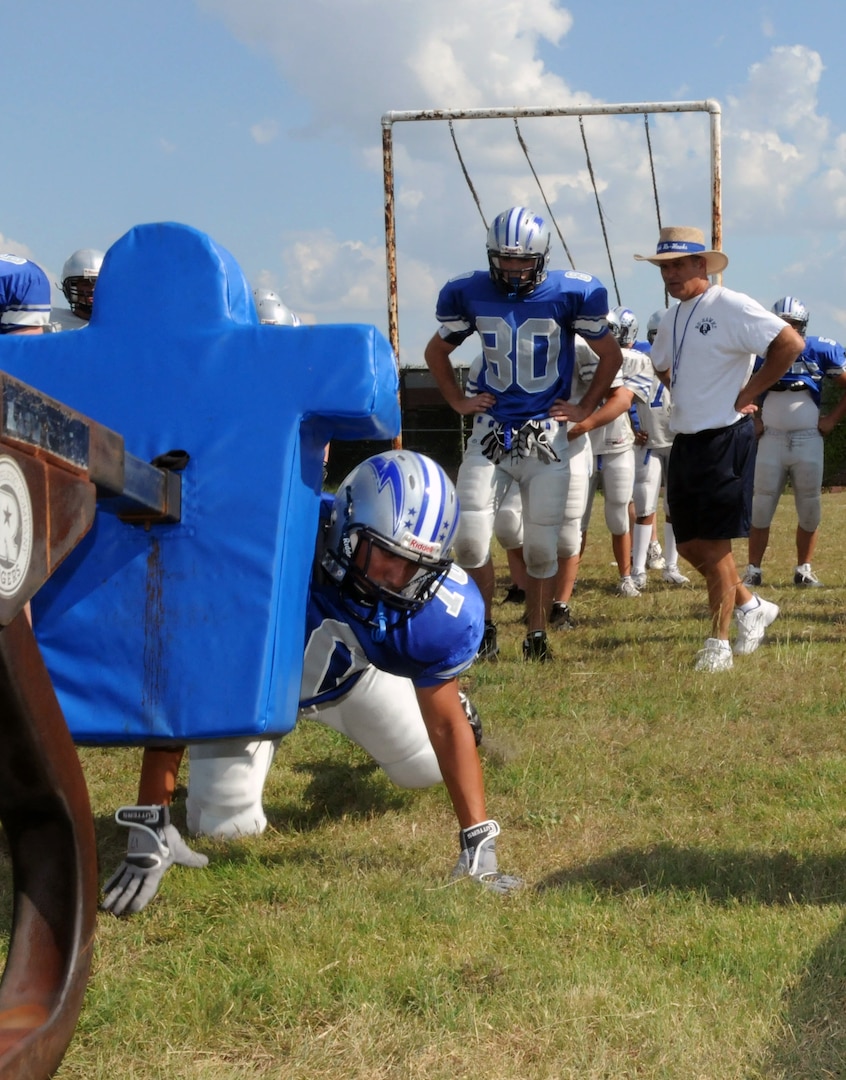 Pete Wesp (right), Randolph head football coach, instucts linemen during a blocking sled drill at a Randolph High School football practice Sept. 22. The Ro-Hawks begin District 27-2A play this weekend against Blanco. (U.S. Air Force photo by Rich McFadden)