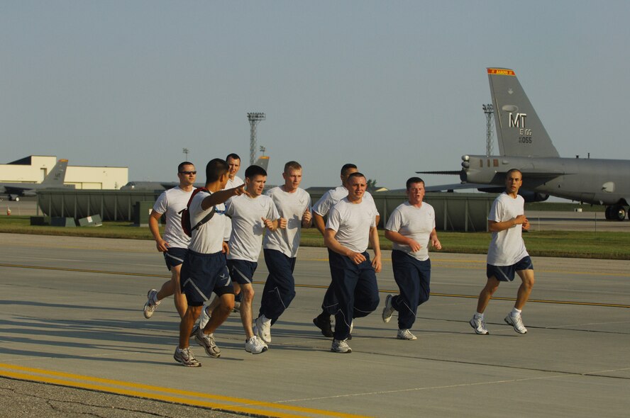 MINOT AIR FORCE BASE, N.D. – Airmen from the 5th Munitions Squadron missile maintenance shop motivate each other while running the 1.5 mile Taxiway Echo Fitness Run here Sept. 19.  The shop ran as a group to build team unity and stopped every quarter mile to do various exercises. (U.S. Air Force photo by Senior Airman Cassandra Jones)