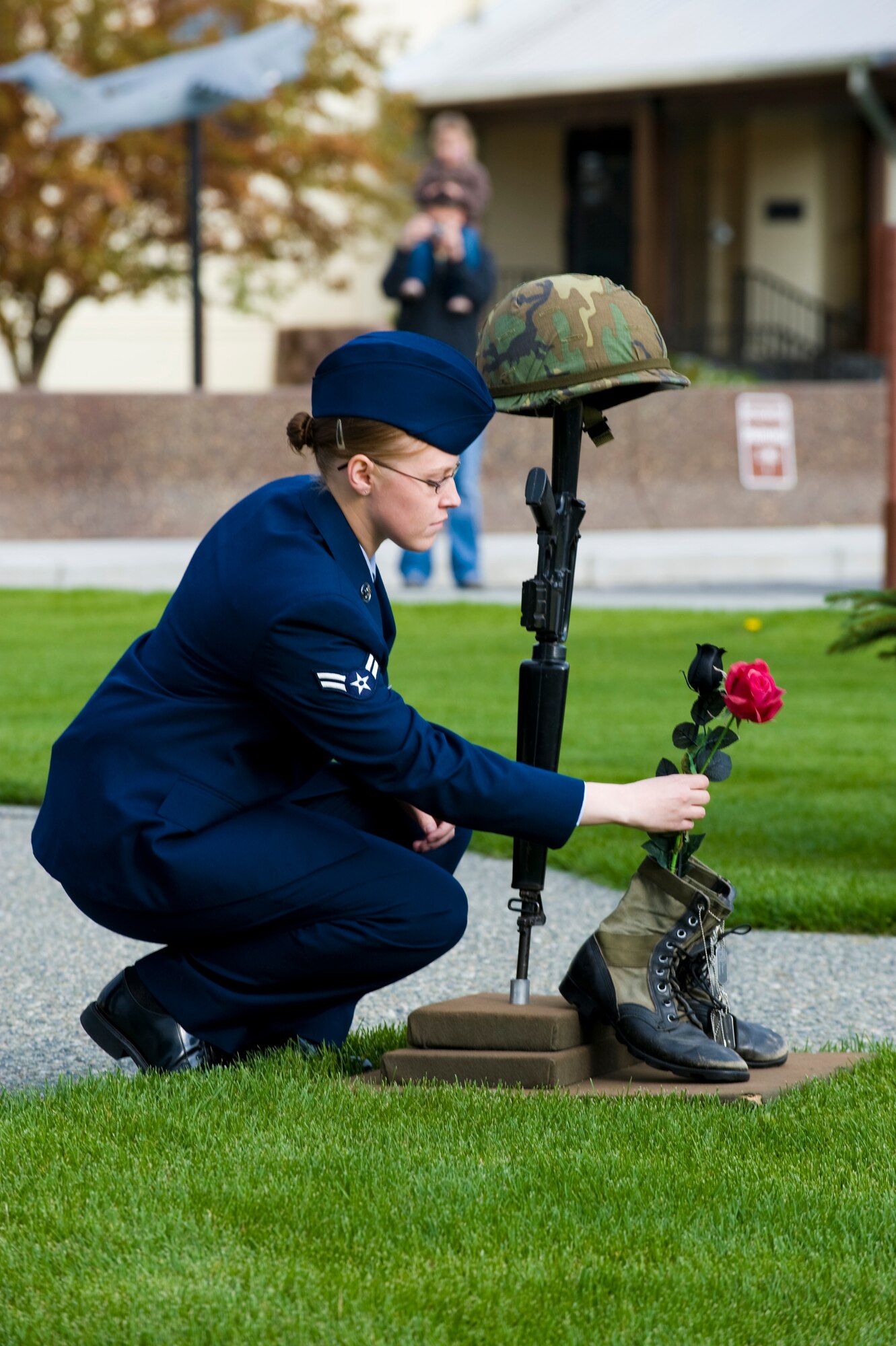 ELMENDORF AIR FORCE BASE Alaska -- Airman 1st Class Megan Darelius, 3rd Equipment Maintenance Squadron, places a rose on a fallen soldier memorial during the POW/MIA ceremony Sept. 19. The memorial consists of several items that would be found on a battle field; a helmet, rifle, boots and dog tags alongside the rose. The rose represents the countries, love, honor and mourning for the fallen warrior. (U.S. Air Force photo/Staff Sgt. Joshua Garcia)
