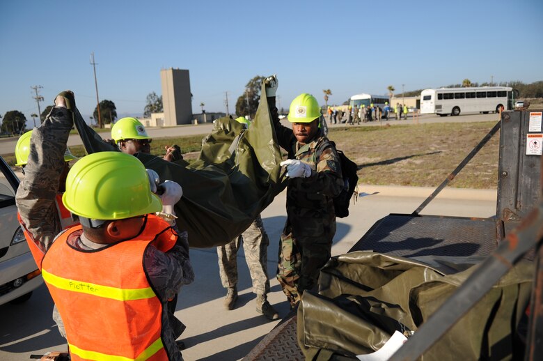 VANDENBERG AIR FORCE BASE, Calif-- Airmen with the Vandenberg Search and Recovery Team lift the remains of a victim onto the simulated medical freezer after a simulated C-17 crash Sep. 17 here. (U.S. Air Force photo/Airman 1st Class Andrew Satran)