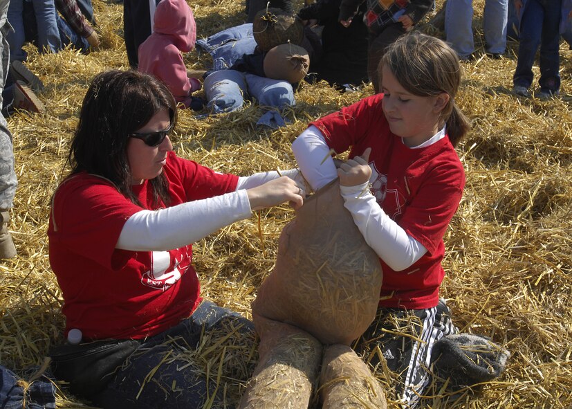 MINOT AIR FORCE BASE, N.D. — Amy and Megan Lisner build a scarecrow during the 10th annual Fall Festival sponsored by the 741st Missile Squadron here Sept. 20. The Minot Fall Festival was held at the base shoppette parking lot here and featured a variety of events for kids young and old. (U.S. Air Force photo by Airman 1st Class Jesse Lopez)