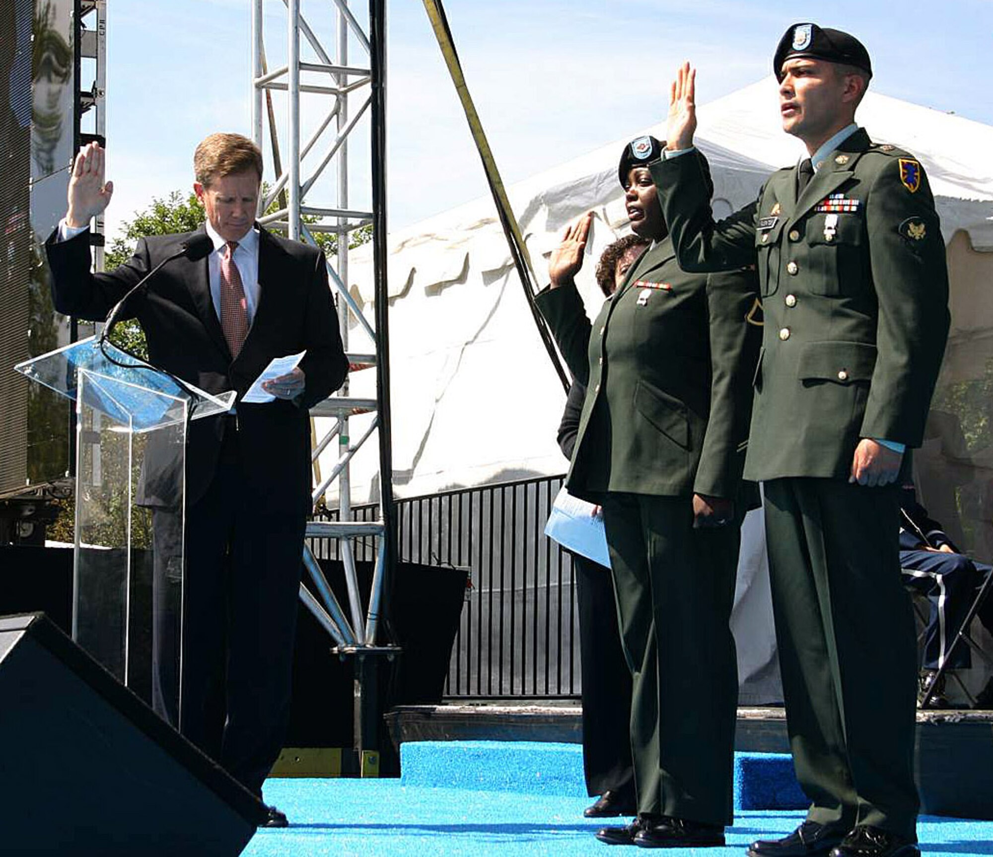 Jonathan Scharpen (left) administers the oath of citizenship to Army Spc. Nakisha Simon and Army Spc. Morgan Facundo at the National Tribute to Honor America's Fallen and Their Families Sept. 20 in Washington, D.C. Mr. Scharpen is the director of U.S. Customs and Immigration Service. (U.S. Air Force photo/Senior Master Sgt. Raymond Sarracino) 
