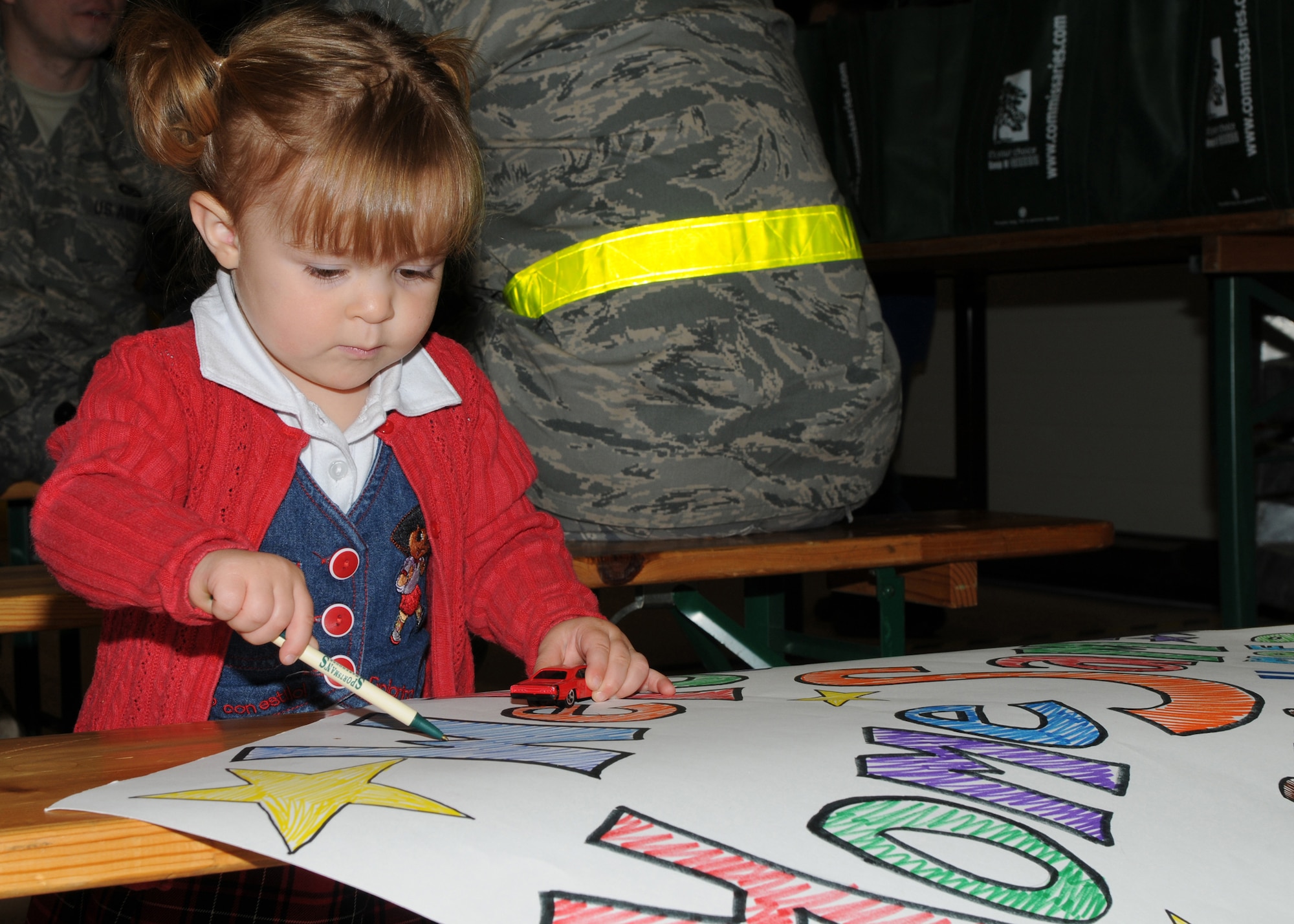 Miya Rhodes, daughter of Staff Sgt. Richard Rose, 606th Air Control Squadron, plays with a sign Sept. 19, 2008, as she waits to see her father who has been deployed to Southwest Asia in support of Operation Enduring Freedom.  (U.S. Air Force photo by Staff Sgt. Heather M. Norris)
