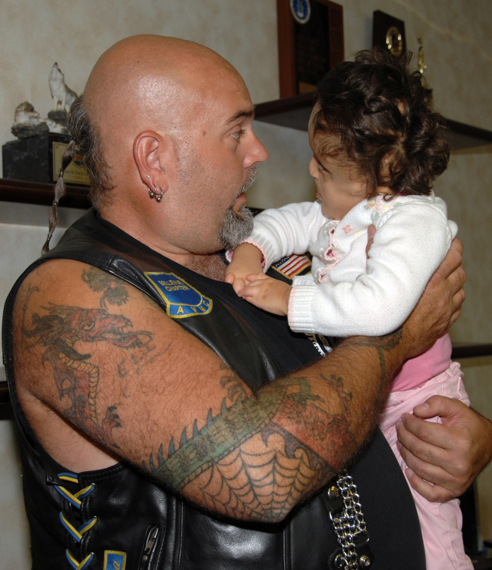 James Whitmire, president for Bellevue’s Chapter of the American Veterans Motorcycle Club, spends some time with Lorilei Todd, daughter of 1st Lt. Matthew and Monica Todd, recently. The AVMC raises money each year through a poker run to donate to military families with hardships. (U.S. Air Force Photo By Kendra Williams)