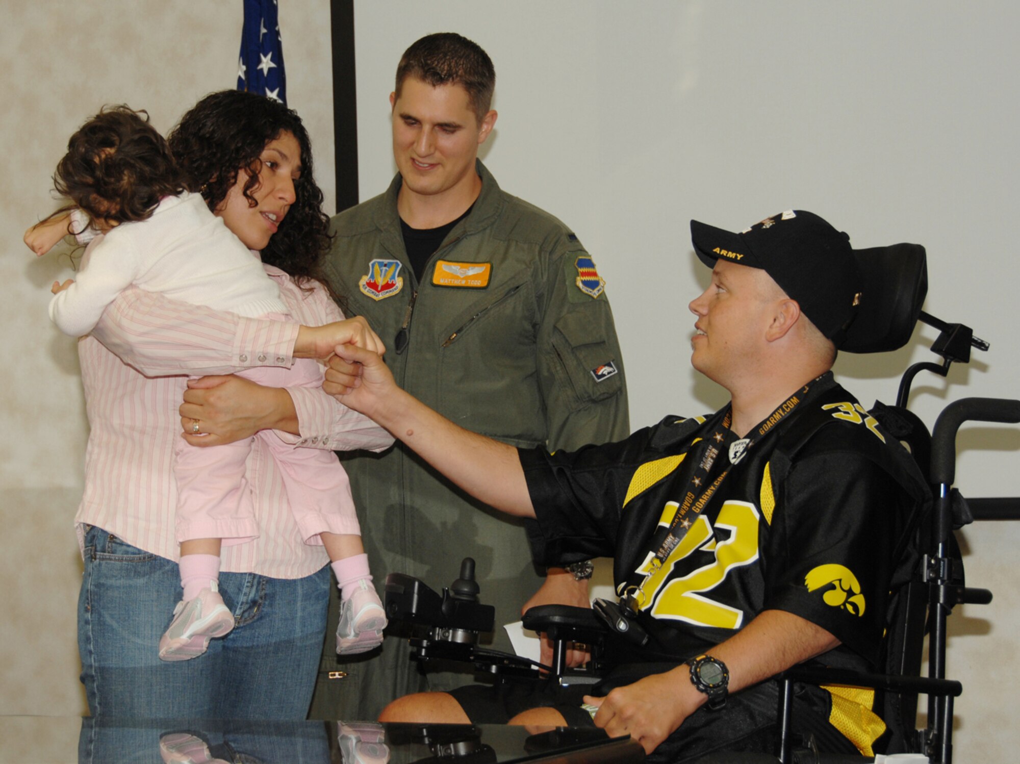 Monica Todd, her husband 1st Lt. Matthew Todd and daughter Lorilei, a special needs child, meet John Weinburgh, a disabled Army veteran, during a special ceremony recently. Both the Todd family and Mr. Weinburgh received donation from the Bellevue Chapter of the American Veterans Motorcycle Club. The AVMC raises money each year through a poker run to donate to military members and their families facing hardships. (U.S. Air Force Photo By Kendra Williams)