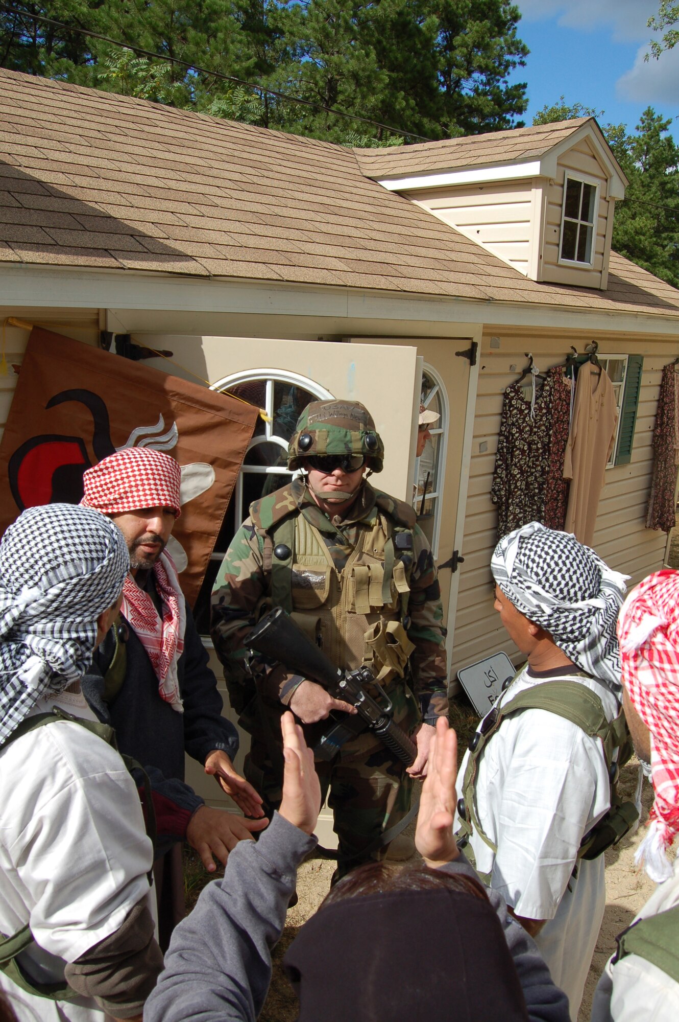 First Lt. William Newby, 95th Communications Group, Edwards Air Force Base, Calif., talks to villagers in the fictional village of "Citheron" Sept. 19, 2008, as part of a scenario for Air Force Exercise Eagle Flag 08-6 at Naval Air Engineering Station Lakehurst, N.J. The exercise is managed by the U.S. Air Force Expeditionary Center's 421st Combat Training Squadron at Fort Dix, N.J., and tests and trains Airmen in expeditionary combat support skills. (U.S. Air Force Photo/Senior Airman Julius Delos Reyes)