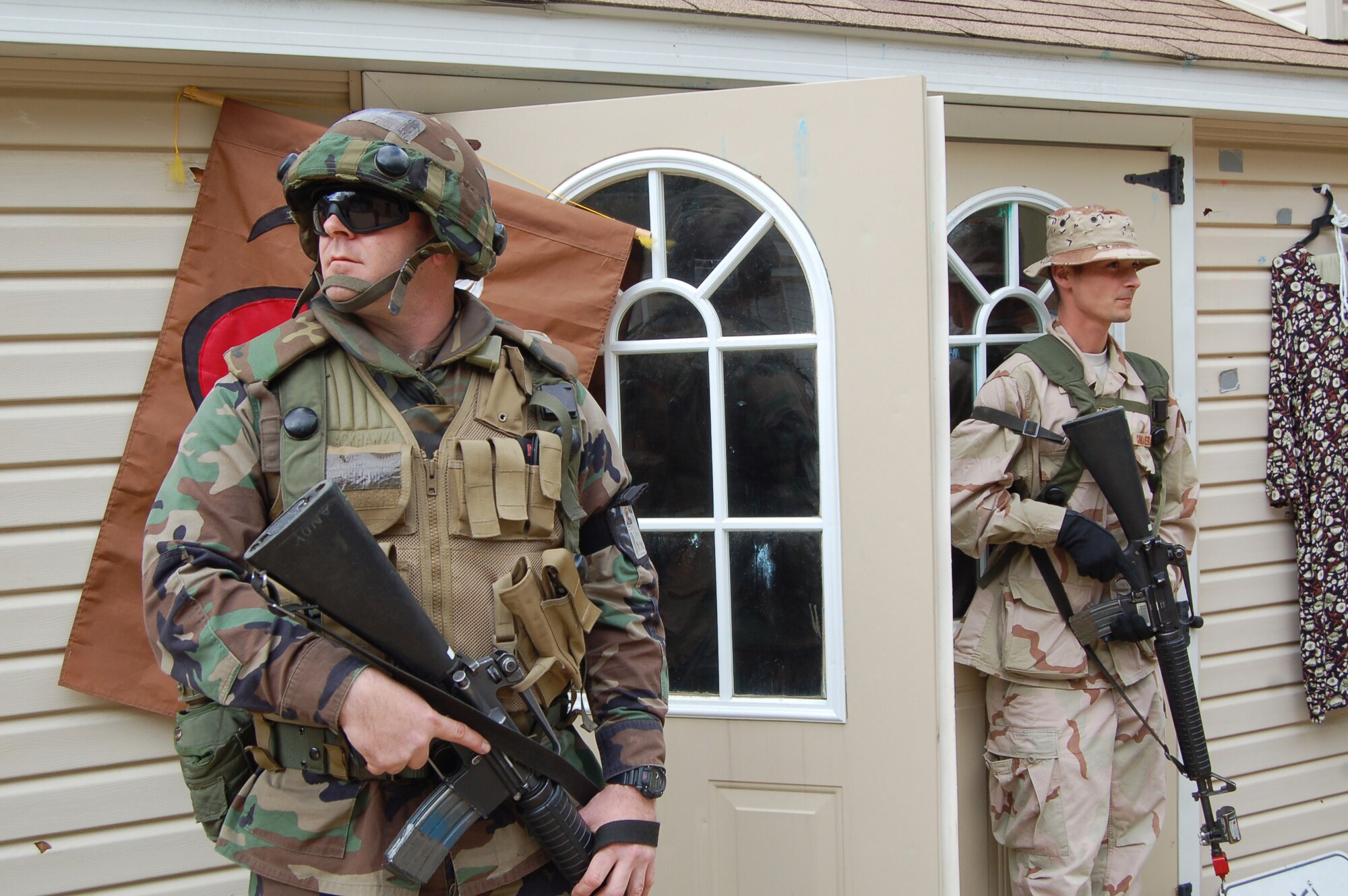 American and "host nation" forces guard a village cafe where they are hosting a joint meeting with the village chieftain during a scenario for Air Force Exercise Eagle Flag 08-6 Sept. 19, 2008, at Naval Air Engineering Station Lakehurst, N.J.. The exercise is managed by the U.S. Air Force Expeditionary Center's 421st Combat Training Squadron at Fort Dix, N.J., and tests and trains Airmen in expeditionary combat support skills. (U.S. Air Force Photo/Senior Airman Julius Delos Reyes)