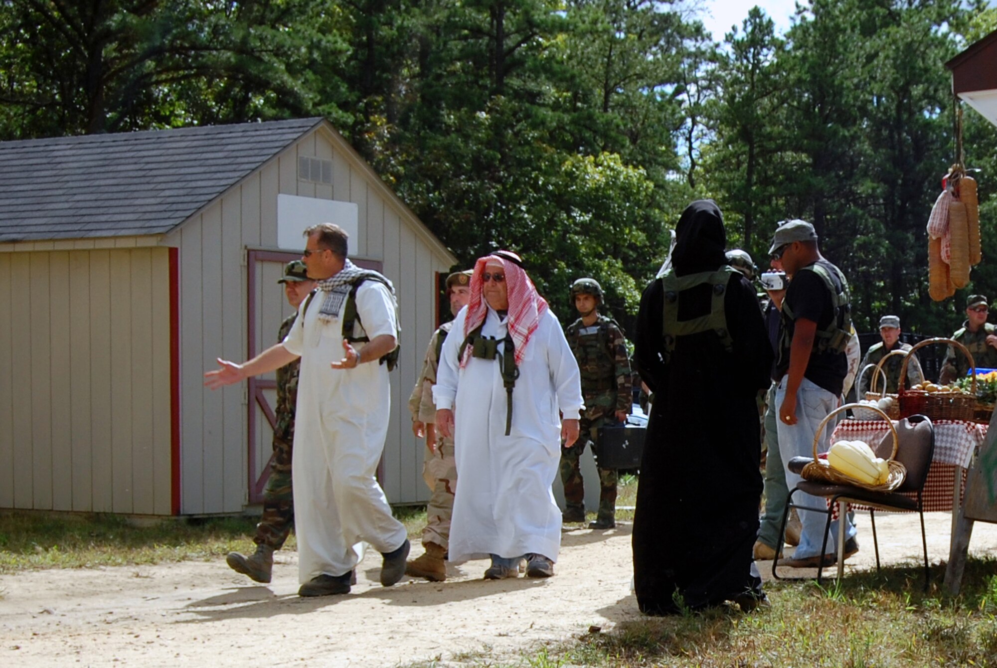 Role players and participants stroll through the fictional village of "Citheron" during a scenario for Air Force Exercise Eagle Flag 08-6 Sept. 18, 2008, at Naval Air Engineering Station Lakehurst, N.J.  Eagle Flag is operated by the U.S. Air Force Expeditionary Center's 421st Combat Training Squadron at Fort Dix, N.J. The purpose of Eagle Flag is to test and train Airmen on expeditionary combat support skills. (U.S. Air Force Force Photo/Staff Sgt. Desiree N. Palacios) 