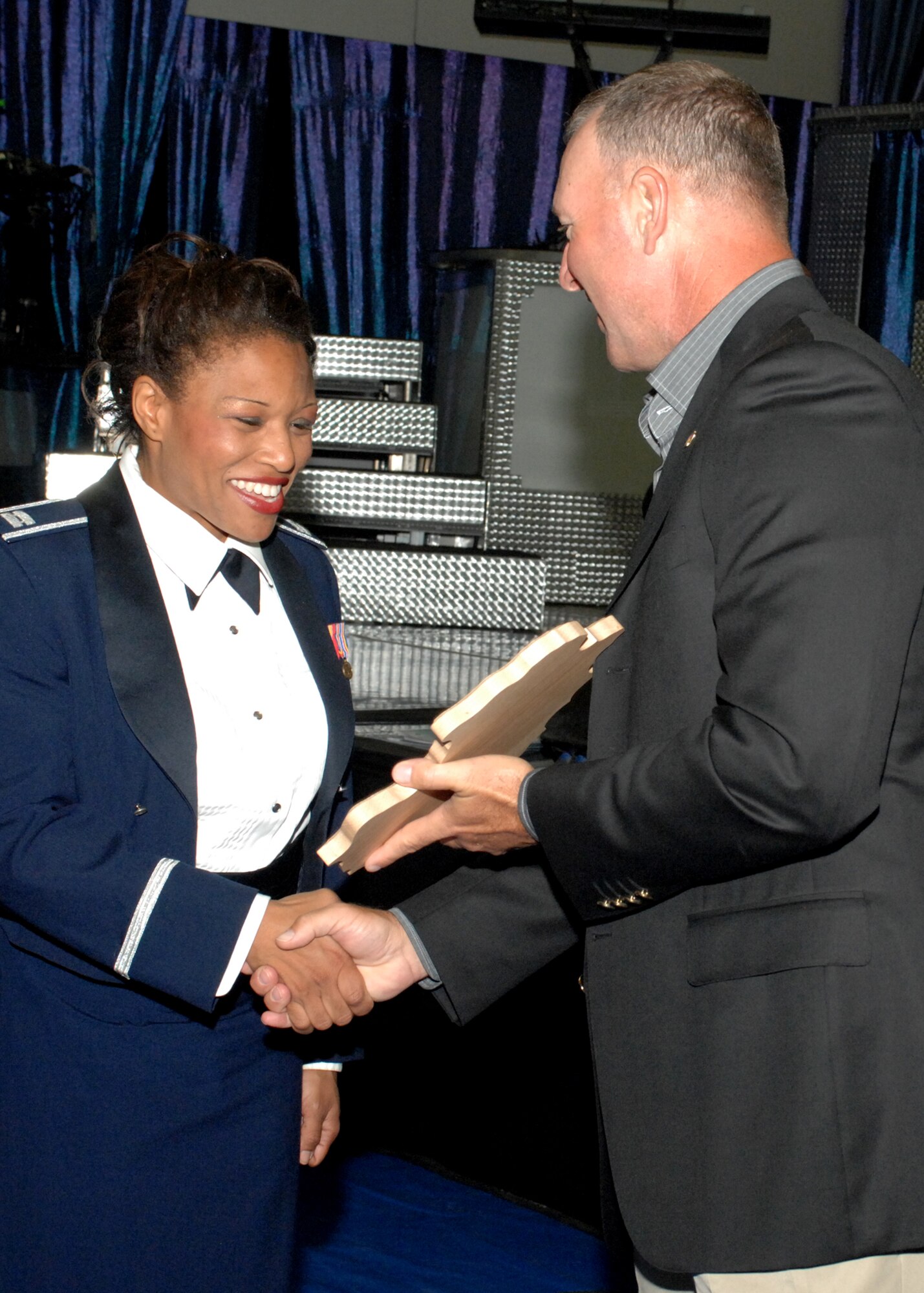 SPANGDAHLEM AIR BASE, Germany – Capt. Courtney Wallace, Tops in Blue tour director and vocalist, receives a plaque from 52nd Fighter Wing Commander Col. Tip Wight following the Tops in Blue performance at the Skelton Memorial Fitness Center Sept. 19, 2008.  This year’s tour celebrates 55 years of entertainment and is titled “Deja Blue”. (U.S. Air Force photo by Airman 1st Class Jenifer H. Calhoun)