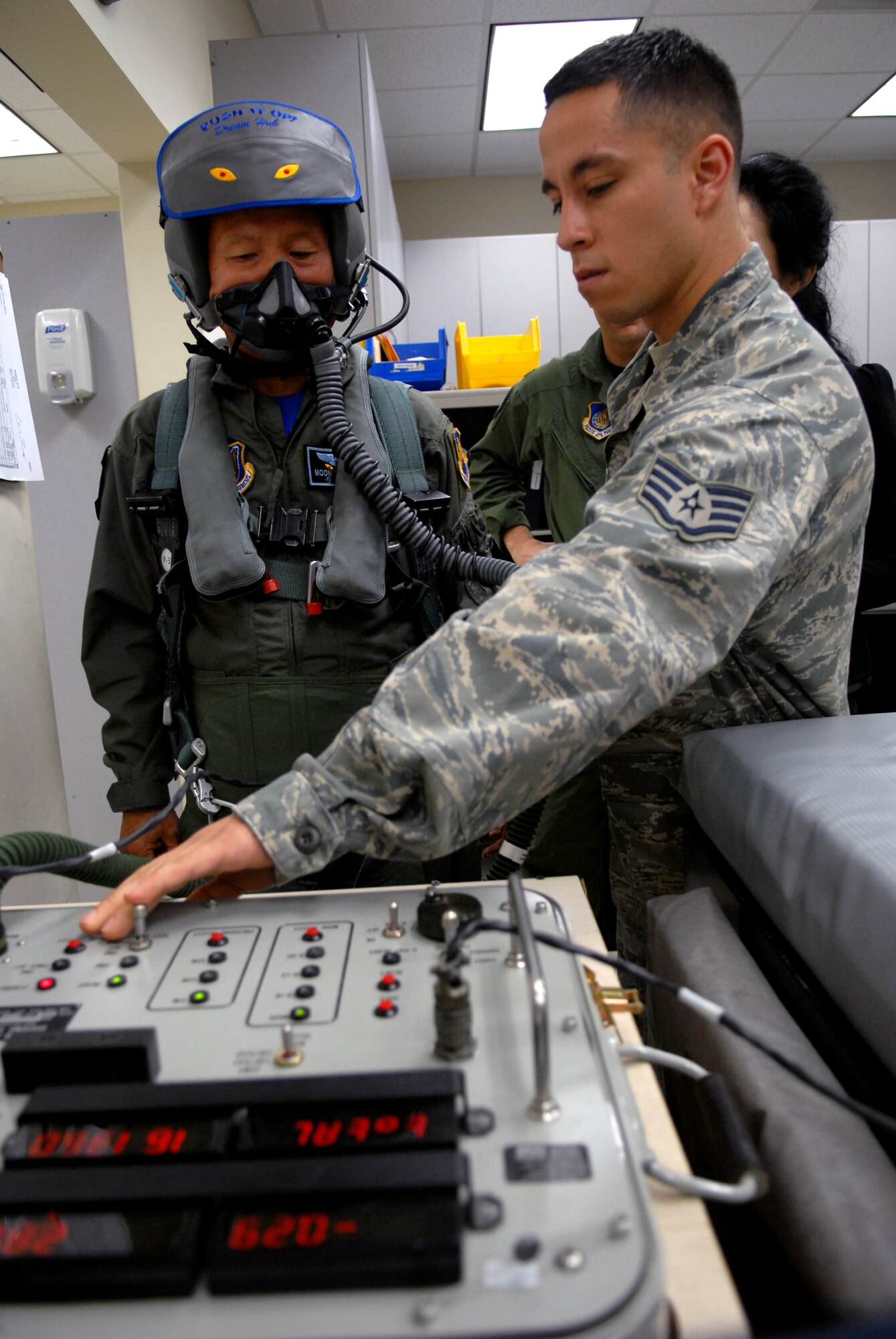 Staff Sgt. Ryan Rios,  an aircrew flight equipment craftsman with the 8th Operations Support Squadron, fits Gunsan City Mayor Dong Shin Moon's mask prior to his high-speed tax ride at Kunsan Air Base, Republic of Korea, Sept. 23. Mayor Moon was participating in the base's Pilot for a Day which is part of USFK's Good Neighbor Program.(U.S. Air Force photo by: Senior Airman Angela Ruiz)