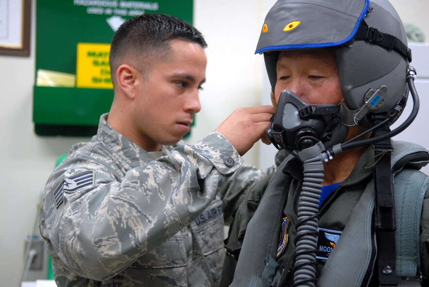 Staff Sgt. Ryan Rios,  an aircrew flight equipment craftsman with the 8th Operations Support Squadron, fits Gunsan City Mayor Dong Shin Moon's mask prior to his high-speed tax ride at Kunsan Air Base, Republic of Korea, Sept. 23. Mayor Moon was participating in the base's Pilot for a Day program which is part of USFK's Good Neighbor Program.(U.S. Air Force photo by: Senior Airman Angela Ruiz)