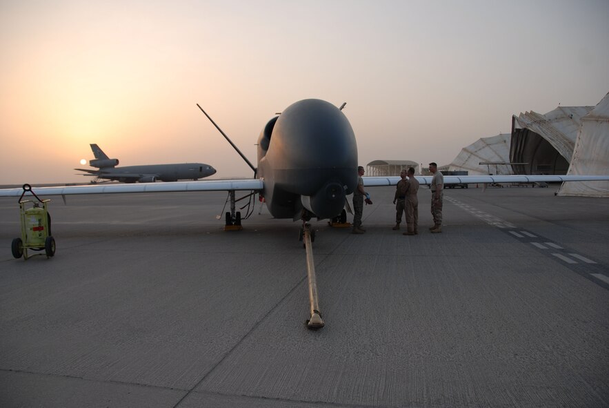 SOUTHWEST ASIA -- Members of the 380th Air Expeditionary Wing discuss the first operationally-flown transatlantic Global Hawk with the wing historian here Sept. 21. It was also the first joint-launch in the history of the aircraft. The unmanned aircraft was only on the ground for about five hours after its historic flight from Pax River, Md., Sept. 20 before being turned around and sent into the Area of Operations. The operational flight also marked the first time two Global Hawks were being flown simultaneously in neighboring theaters in support of Operations Iraqi and Enduring Freedom. (U.S. Air Force photo/Tech. Sgt. Denise Johnson)(released)