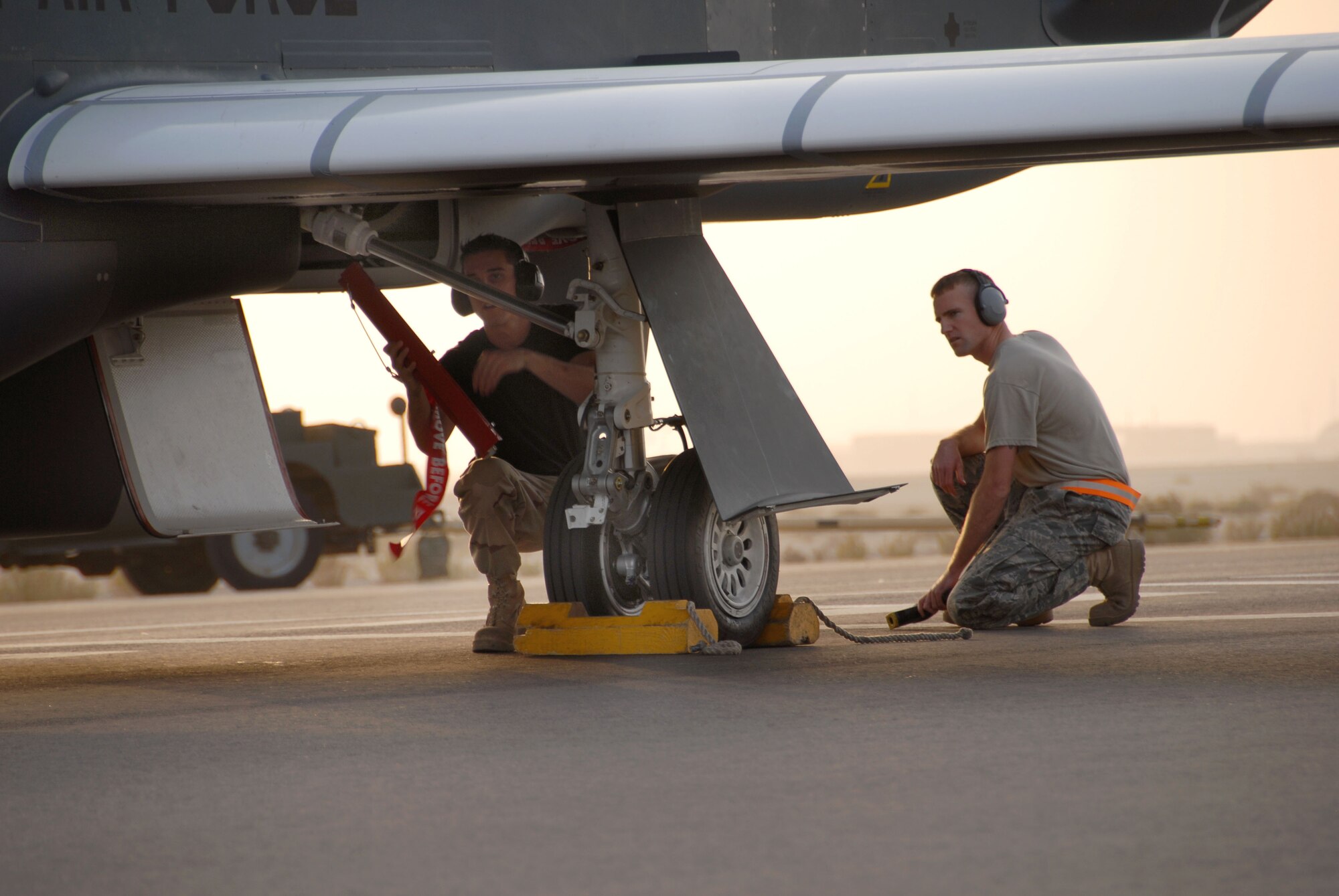 SOUTHWEST ASIA -- Staff Sgt. Craig Peterson and Staff Sgt. Jonathan Leloux (right), avionics system technicians with the 380th Expeditionary Aircraft Maintenance Squadron, attach down locks to the first operational trans-atlantic joint-launched Global Hawk here Sept. 21. The unmanned aircraft just returned from its first sortie out of its new home at the 380th Air Expeditionary Wing here. It was only on the ground for about five hours after its historic flight from PAX River, Md., Sept. 20 before being turned around and sent into the Area of Operations. Both noncommissioned officers are deployed here from the 9th Aircraft Maintenance Squadron's 12th Aircraft Maintenance Unit out of Beale Air Force Base, Calif. Sergeant Peterson hails from North Bend, Ore. Sergeant Leloux is from Georgetown, Texas. (U.S. Air Force photo/Tech. Sgt. Denise Johnson)(released)