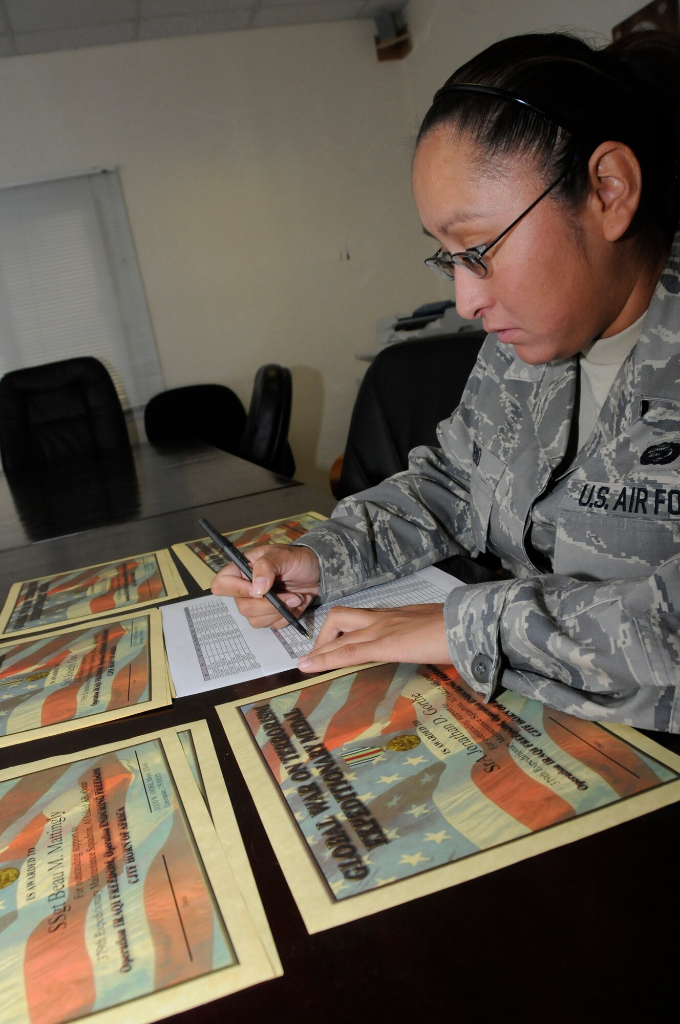 Staff Sgt. Alfreda Rubio, noncommissioned officer in charge of commander support staff, assigned to the 379th Expeditionary Maintenance Squadron, verifies names and ranks on Global War on Terrorism Expeditionary Medal certificates and marks them off a roster Sept. 22, 2008, at an undisclosed air base in Southwest Asia. The Global War on Terrorism Expeditionary Medal is awarded to all personnel deployed in support of Operation Iraqi Freedom and Operation Enduring Freedom. Sergeant Rubio, a native of Tempe, Ariz., is deployed from Luke Air Force Base, Ariz.  (U.S. Air Force photo by Staff Sgt. Darnell T. Cannady/Released)