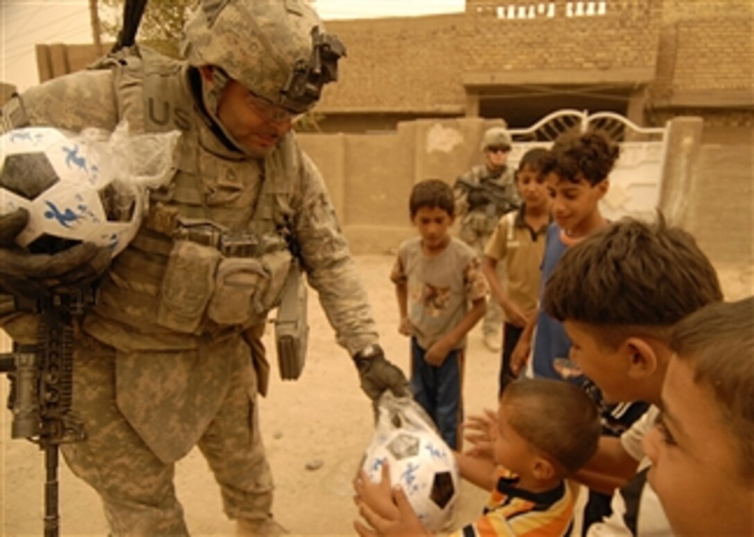U.S. Army Staff Sgt. Rickey Spencer passes out soccer balls to children in Baghdad, Iraq, on Sept. 15, 2008.  Spencer is assigned to the 2nd Platoon, Bravo Company, 4th Battalion, 64th Armor Regiment, 4th Brigade Combat Team, 3rd Infantry Division.  