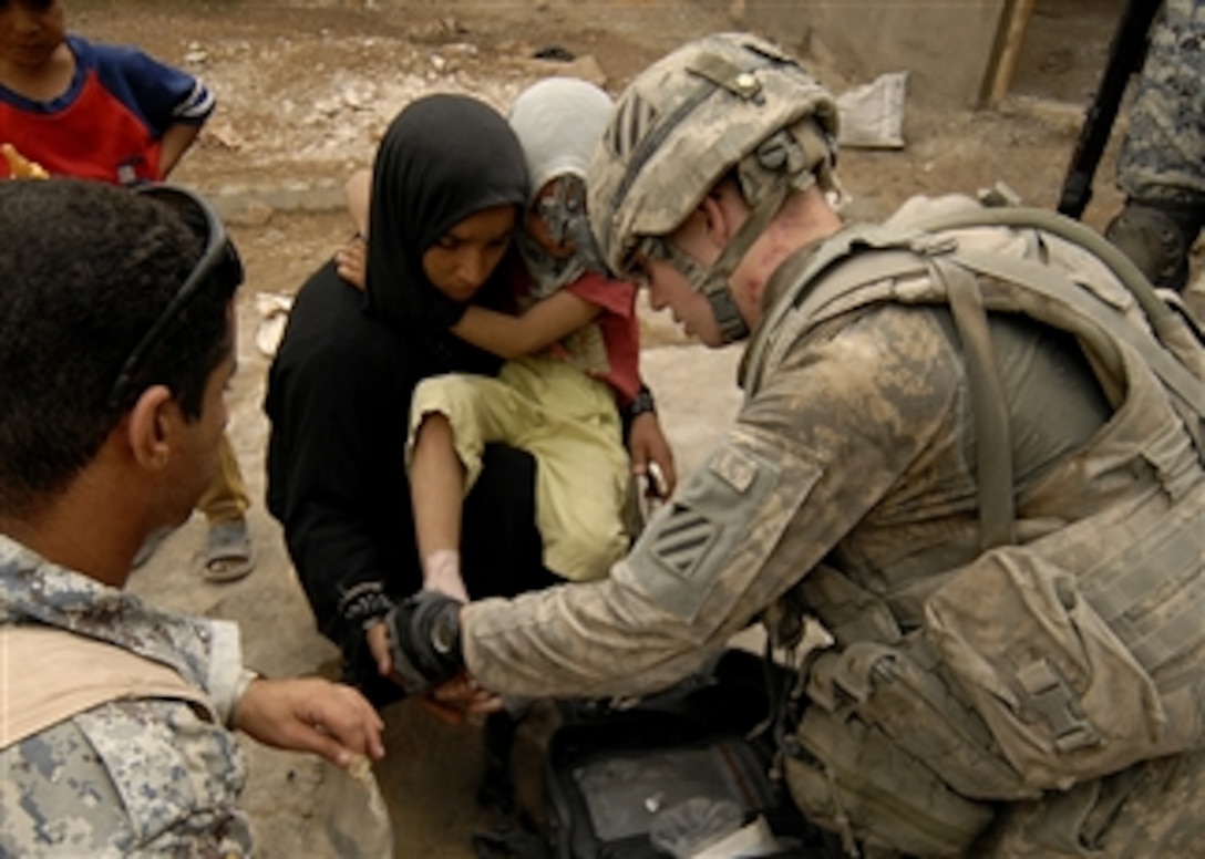 U.S. Army Spc. Matthew Petterson provides medical attention to a girl in Baghdad, Iraq, on Sept. 15, 2008.  Petterson is assigned to the 2nd Platoon, Bravo Company, 4th Battalion, 64th Armor Regiment, 4th Brigade Combat Team, 3rd Infantry Division.  