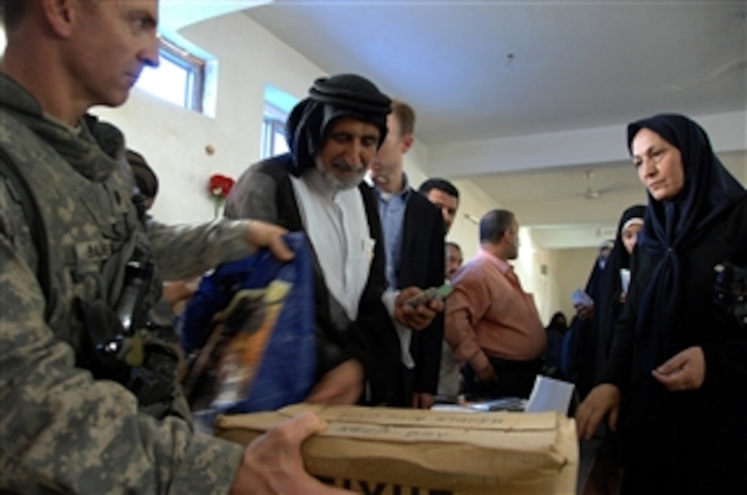 A U.S. Army soldier distributes humanitarian assistance items at a community center in Eastern Baghdad, Iraq, on Sept. 14, 2008.  