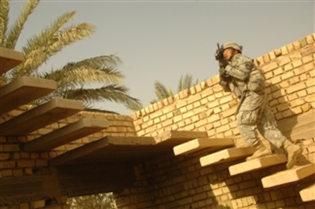 U.S. Army Sgt. Duong Tran moves to a roof top to provide security for other soldiers as they search the roof of a suspect house for hidden weapons caches during a search and cordon patrol in the city of Al Mahmudiyah, Al Mahmudiyah district, Baghdad province, Iraq, on Sept. 4, 2008.  Tran is assigned to the 3rd Battalion, 320th Field Artillery Regiment, 3rd Brigade Combat Team, 101st Airborne Division (Air Assault).  