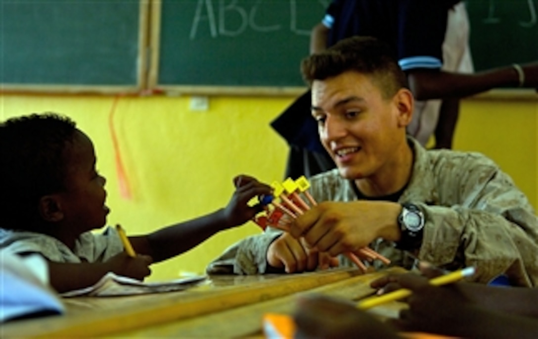 U.S. Marine Corps Lance Cpl. Kyle Tucker gives a pencil to a young boy during a civil affairs visit to an elementary school in Damerdjog, Djibouti, on Sept. 17, 2008.  Tucker is assigned to the 8th Provisional Security Company deployed to Camp Lemonier, Djibouti.  The 8th Provisional Security Company is part of the Combined Joint Task Force - Horn of Africa.  
