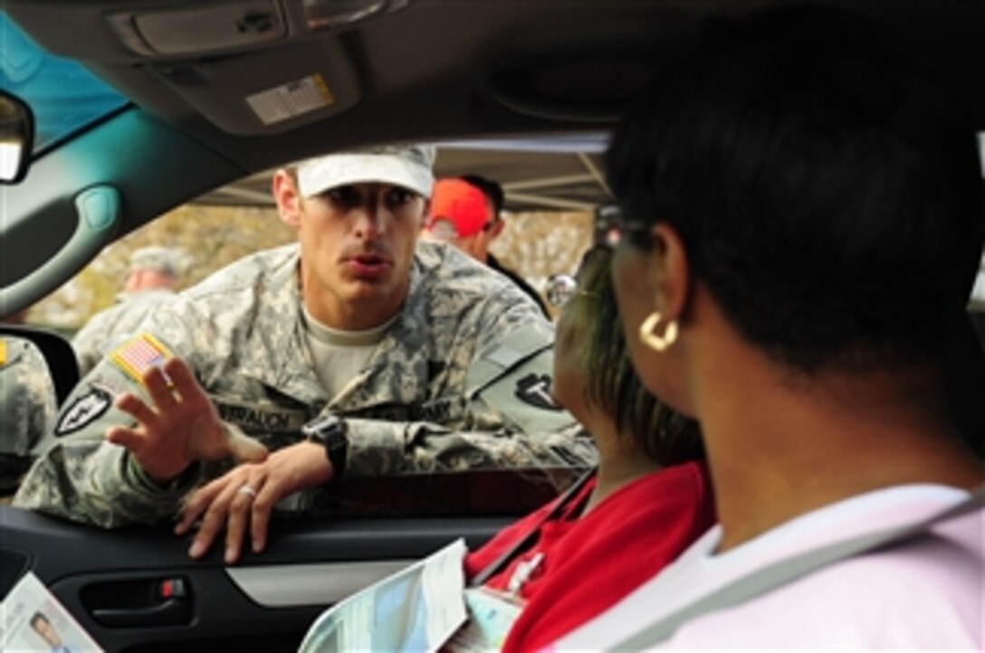 U.S. Army Spc. Peter Strauch, of the Texas Army National Guard, explains Federal Emergency Management Agency relief efforts to citizens at a point of distribution site in Galveston, Texas, on Sept. 19, 2008.  The U.S. Army is contributing to the Hurricane Ike humanitarian assistance operations being led by the Federal Emergency Management Agency in conjunction with the Department of Defense.  