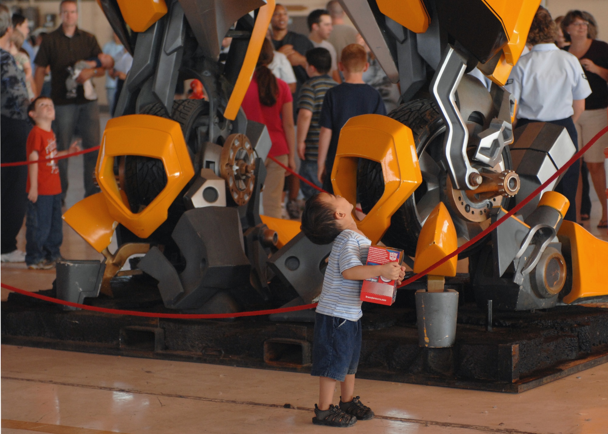 A little boy from Holloman Air Force Base, N.M., looks up at the character from the Transformers 2 movie, ?Optimas Prime,? at Hanger 500, September 22. Dream Works filmed parts of the movie at Holloman and gave Team Holloman a chance to bring family to see and view props from the movie. (U.S. Air Force photo/Airman 1st Class Veronica Salgado)