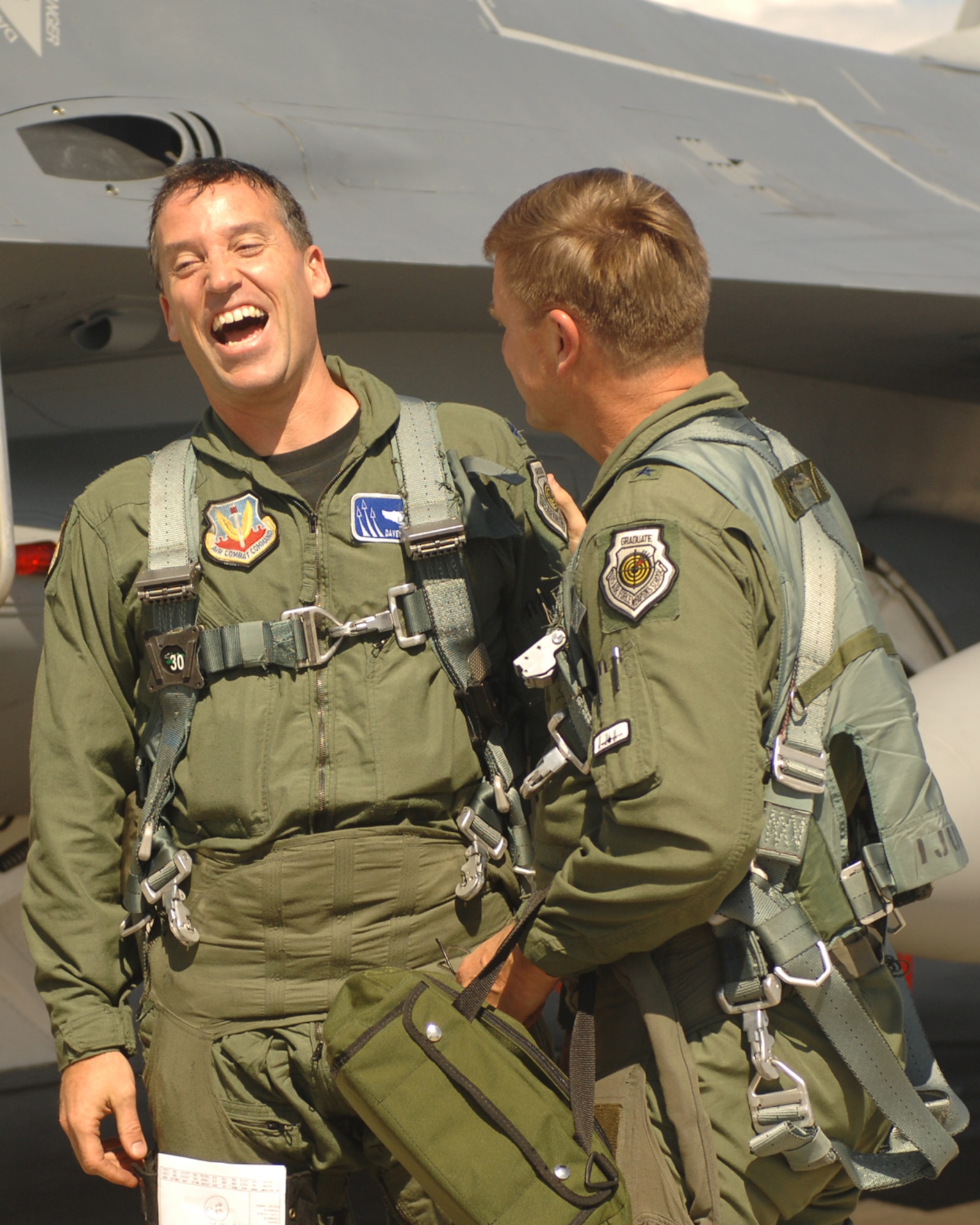 Lt. Col. David Thirtyacre, U. S. Air Force Warfare Center Deputy A3 (center), talks with Brig. Gen. Stephen L. Hoog, United States Air Force Warfare Center commander, after completing a sortie in an F-16 with the general. The sortie took Colonel Thirtyacre over the 3,000-flying-hour mark in the F-16 Fighting Falcon. (U.S. Air Force Photo by SrA Jason Huddleston)
