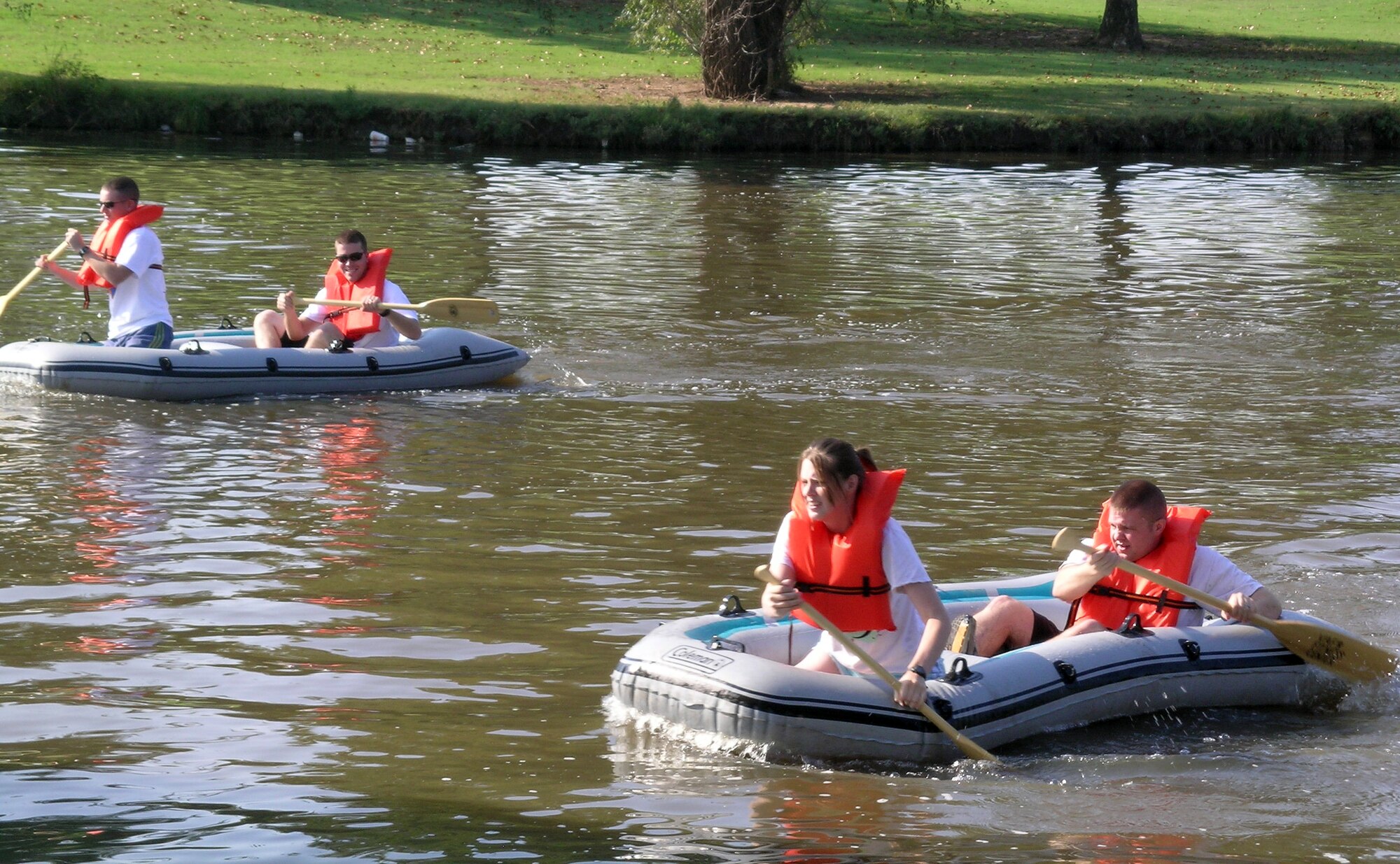 Two of the 12 relay teams entered in the Vance AFB 2008 Adventure Race, the “Nacho Nachos” and the “Average Joes,” paddle it out at Meadowlake Park in Enid, Okla., during the 2-mile raft portion of the race, Sept. 20. The race course began and ended on base. “War Birds,” took first place in the Relay Teams category with an overall time of 1:37:10.  (U.S. Air Force photo by Sarah Putnam) 