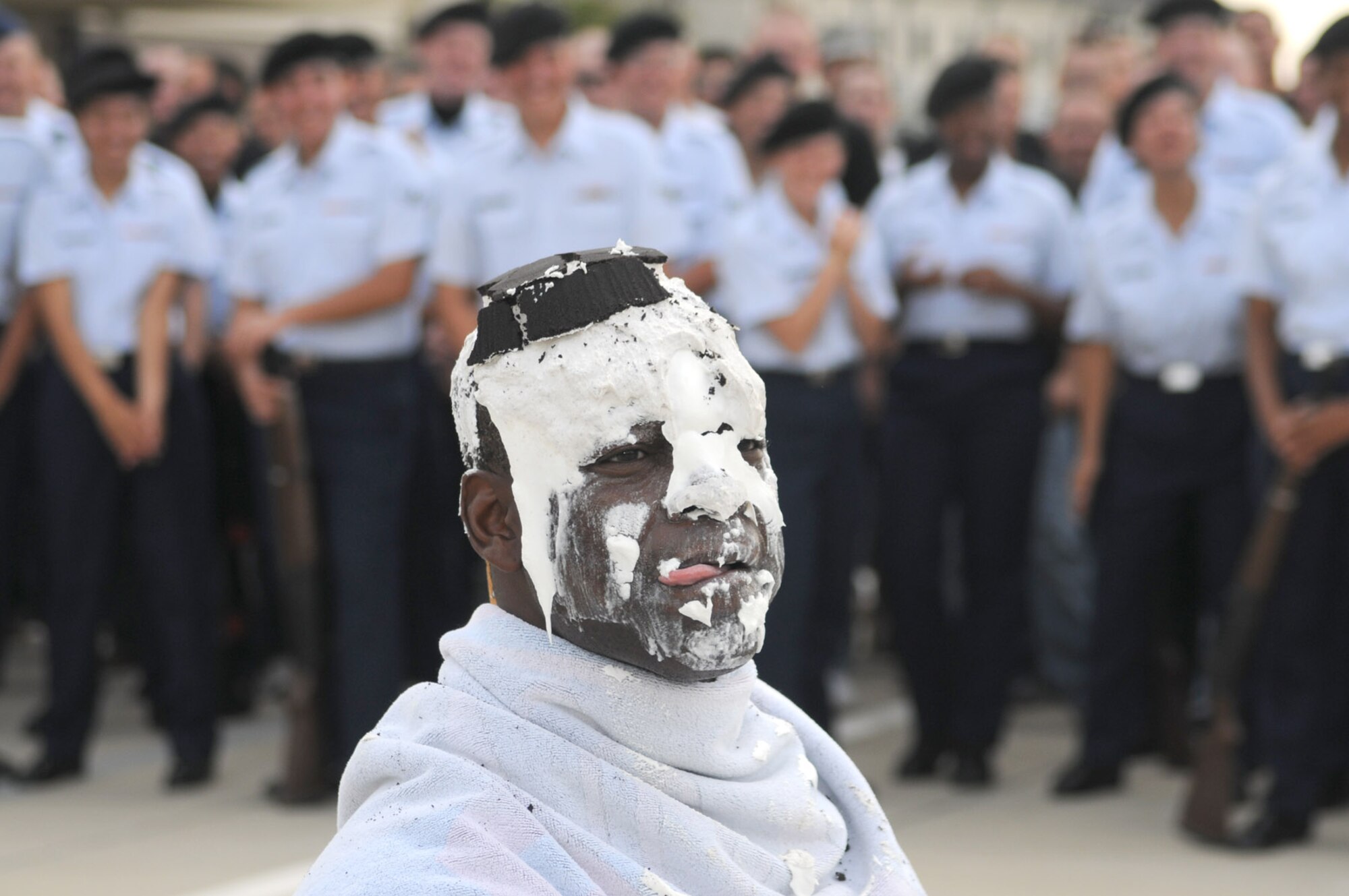 Col. Prince Gilliard, 81st TRG commander, licks some of the whipped cream from the pie thrown in his face by Airman 1st Class Anne Marie Benitez, a student in the 336th TRS.  Technical training students from the 335th TRS, 336th TRS and 338th TRS raised $1,517 for the Red Cross in response to news reports about the organization’s financial shortfalls after responding to recent flooding and hurricanes.  (U.S. Air Force photo by Kemberly Groue)