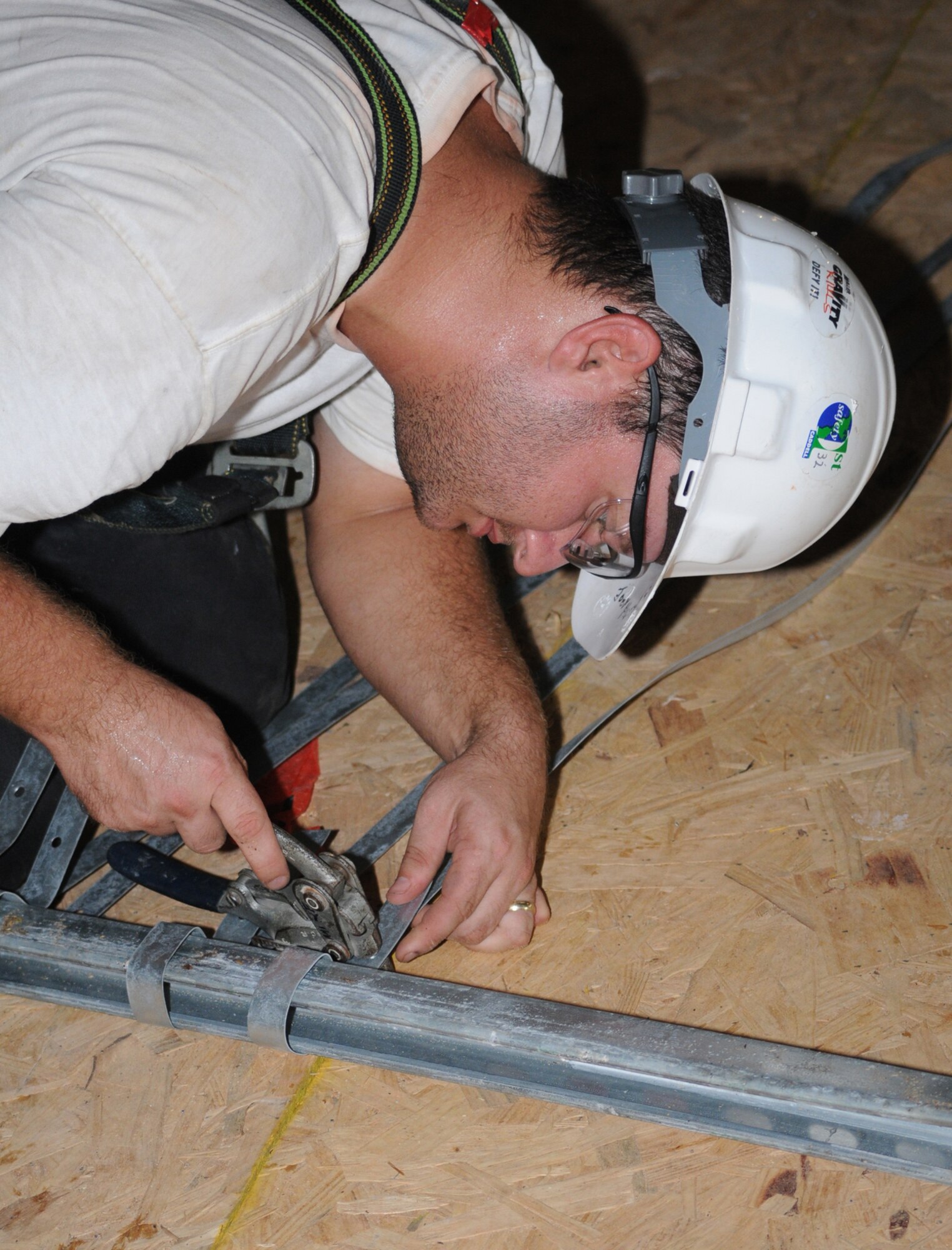 Journeyman Joey Hunt presets hangars for the commissary’s air ducts.  (U.S. Air Force photo by Kemberly Groue)