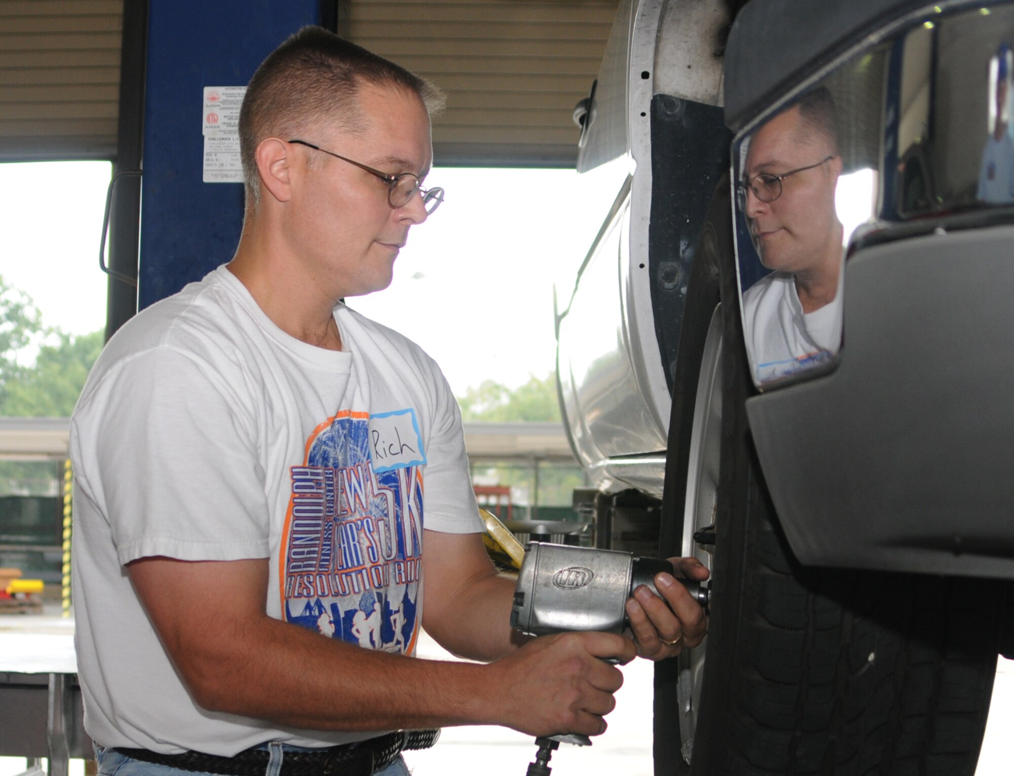 Maj. Rich Cole, 81st Force Support Squadron commander, changes a tire on a truck in the auto hobby shop.  The arts and crafts center held an expo Friday to acquaint Keesler commanders with its programs, services and facilities.  (U.S. Air Force photo by Kemberly Groue)